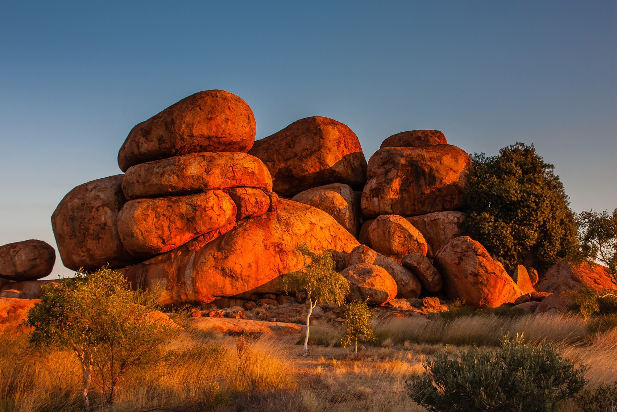 Große, rötliche Felsen in Kugelform in der Steppe in der Abendsonne Große, rötliche Felsen in Kugelform in der Steppe in der Abendsonne