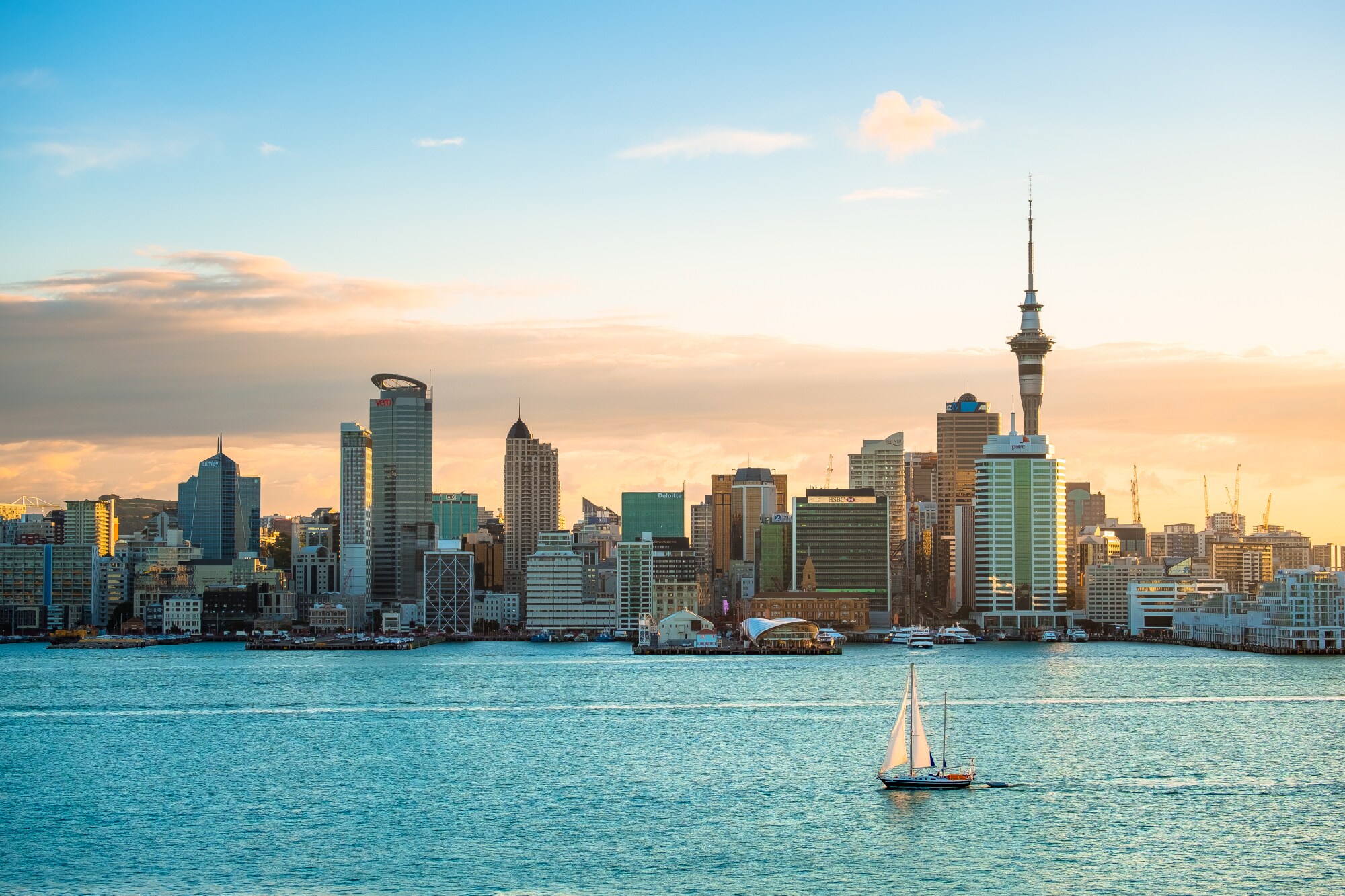 Stadtpanorama von Auckland am Wasser mit einem Segelboot im Vordergrund