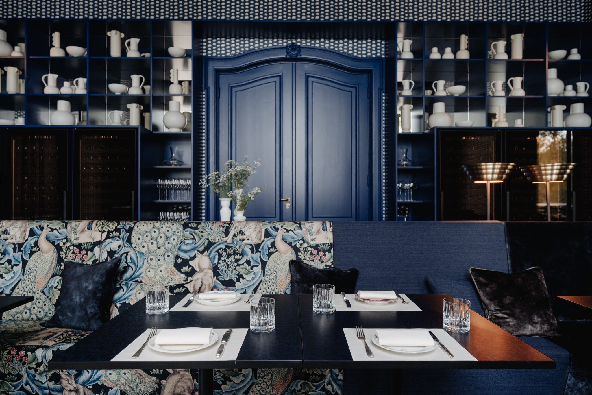 Ein gedeckter Tisch in einem edel wirkenden und mit weißem Porzellan dekorierten Raum