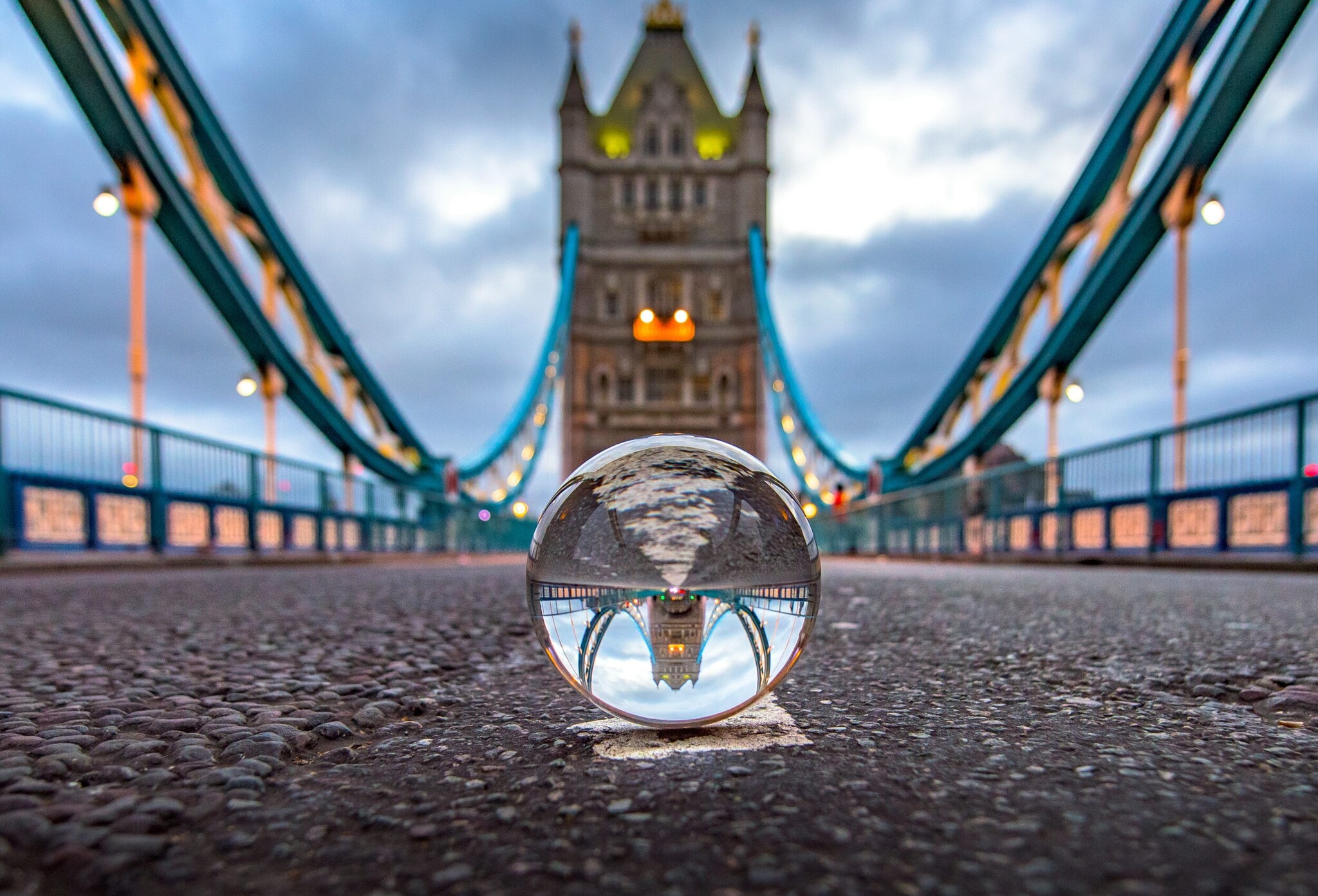 Die London Tower Bridge, die sich in einer Glaskugel spiegelt und selbst unscharf im Hintergrund zu sehen ist Die London Tower Bridge, die sich in einer Glaskugel spiegelt und selbst unscharf im Hintergrund zu sehen ist