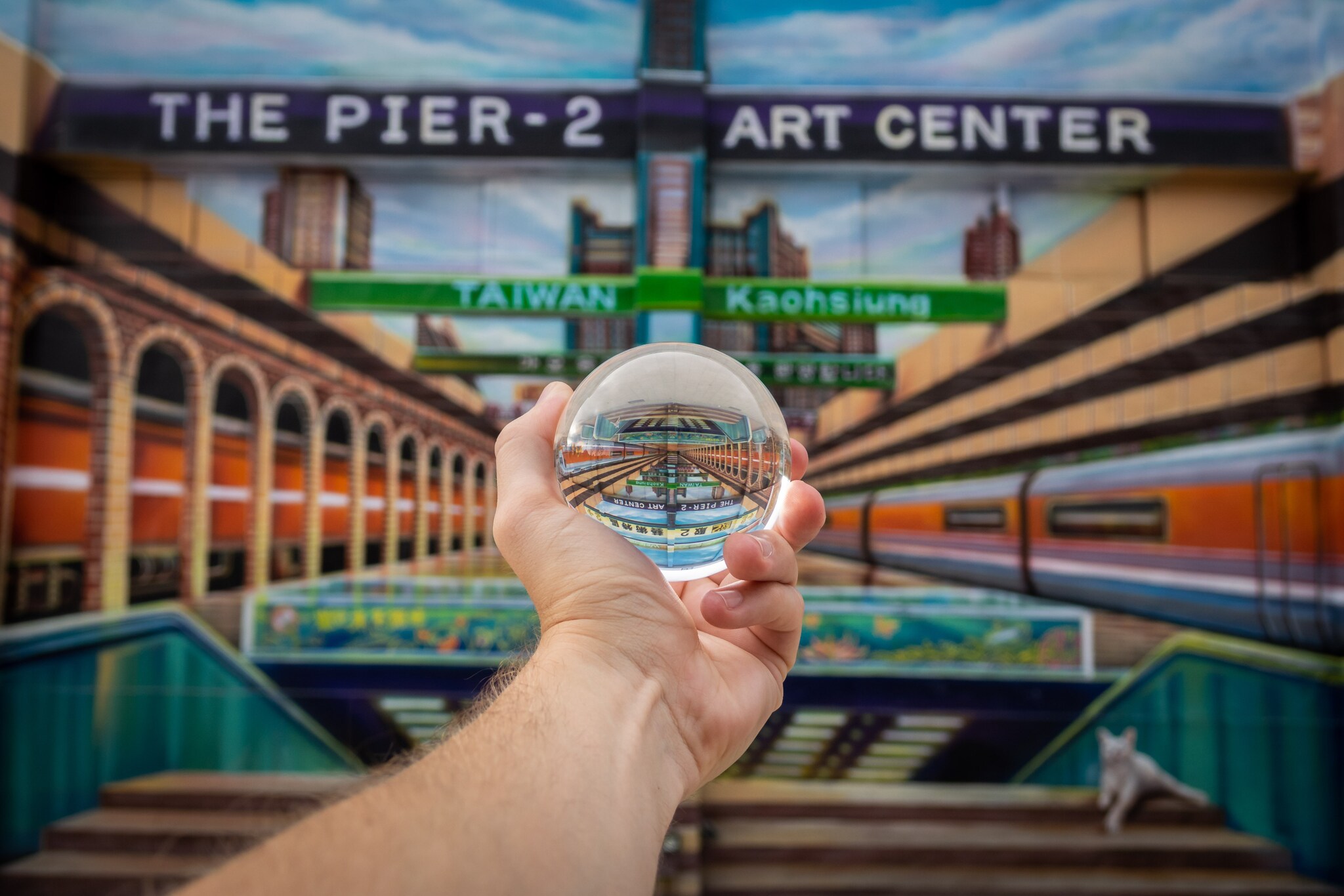 Ein ausgestreckter Arm, der eine Glaskugel hält.