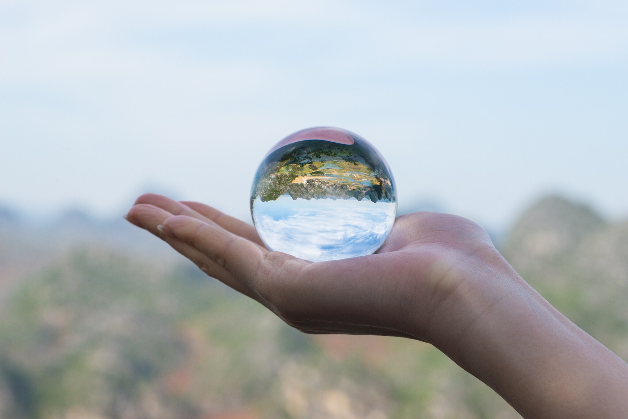Eine Hand hält eine Glaskugel in der Hand