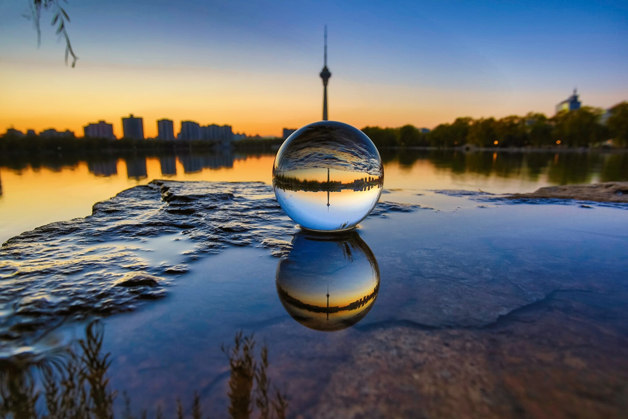 Skyline einer Stadt durch eine Glaskugel im Sonnenuntergang fotografiert Skyline einer Stadt durch eine Glaskugel im Sonnenuntergang fotografiert