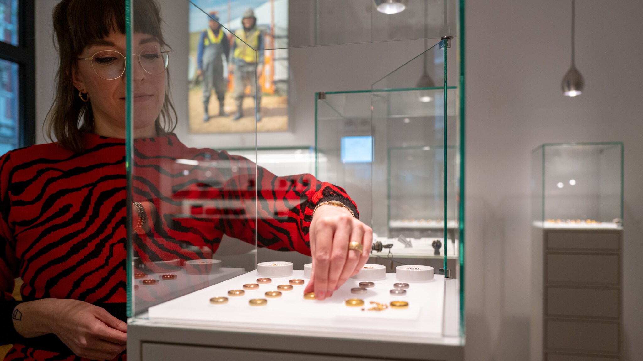Beraterin legt im Atelier von Jan Spille Ringe in eine Vitrine