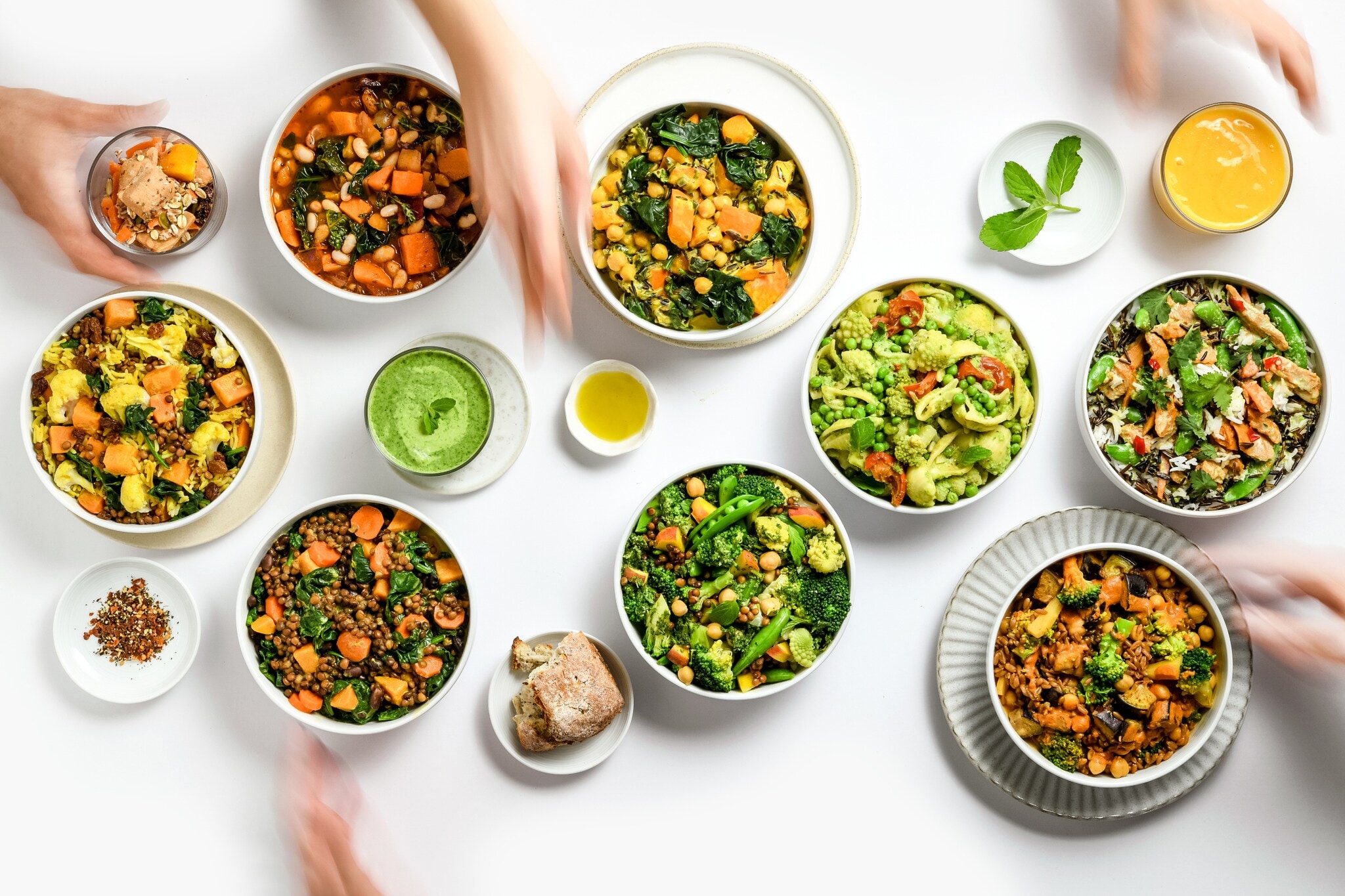 Mehrere Schüsseln mit Gemüse auf einem weißen Tisch Mehrere Schüsseln mit Gemüse auf einem weißen Tisch