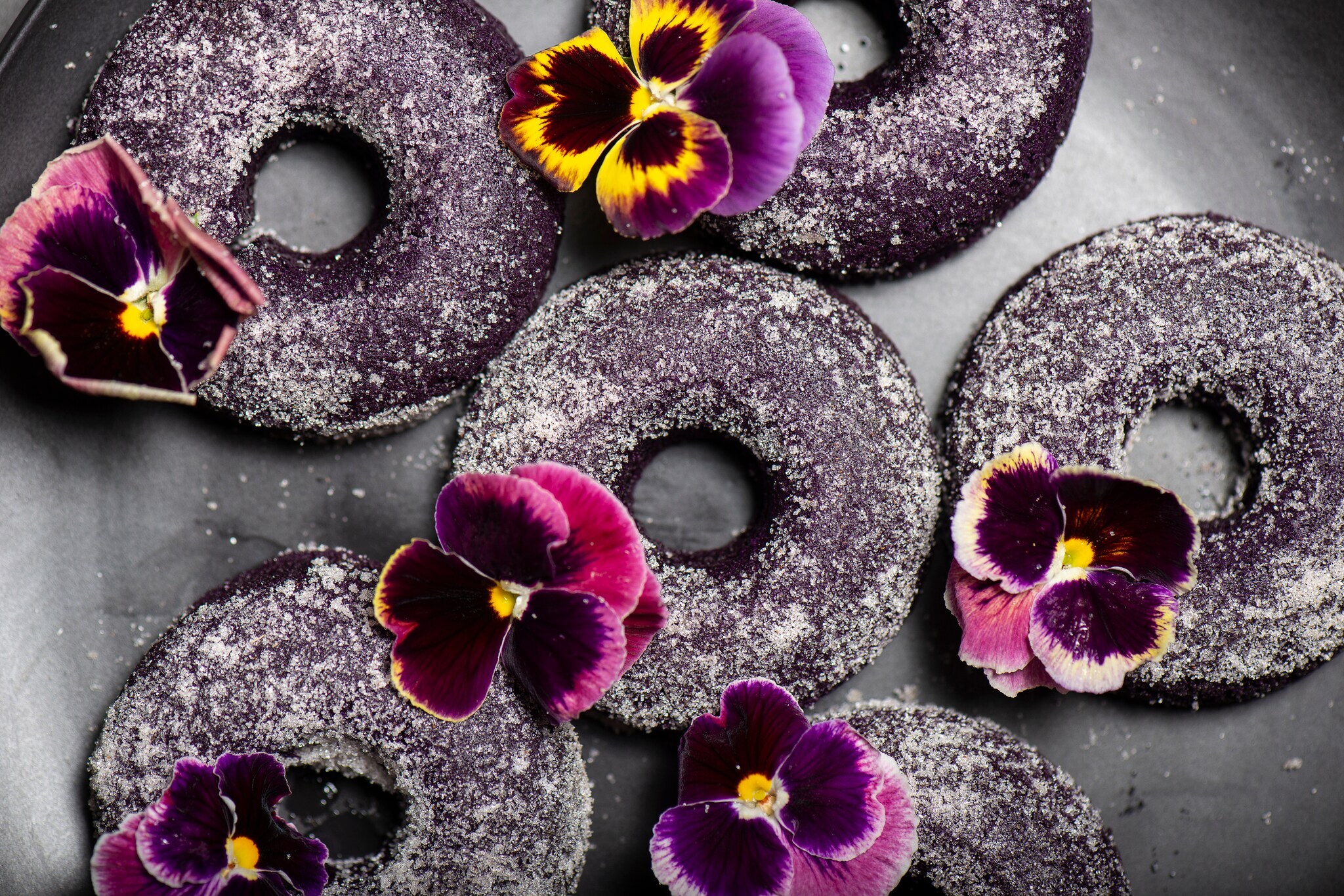 Lila Yamswurzel in Donutform, mit Blumen dekoriert