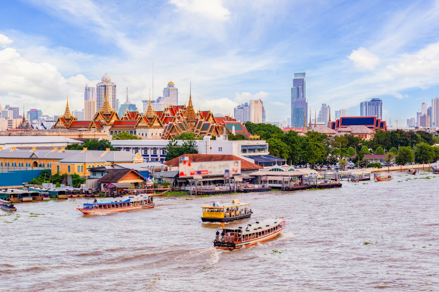 Der Fluss Chao Phraya auf dem Schiffe unterwegs sind, im Hintergrund ist die Skyline von Bangkok zu sehen