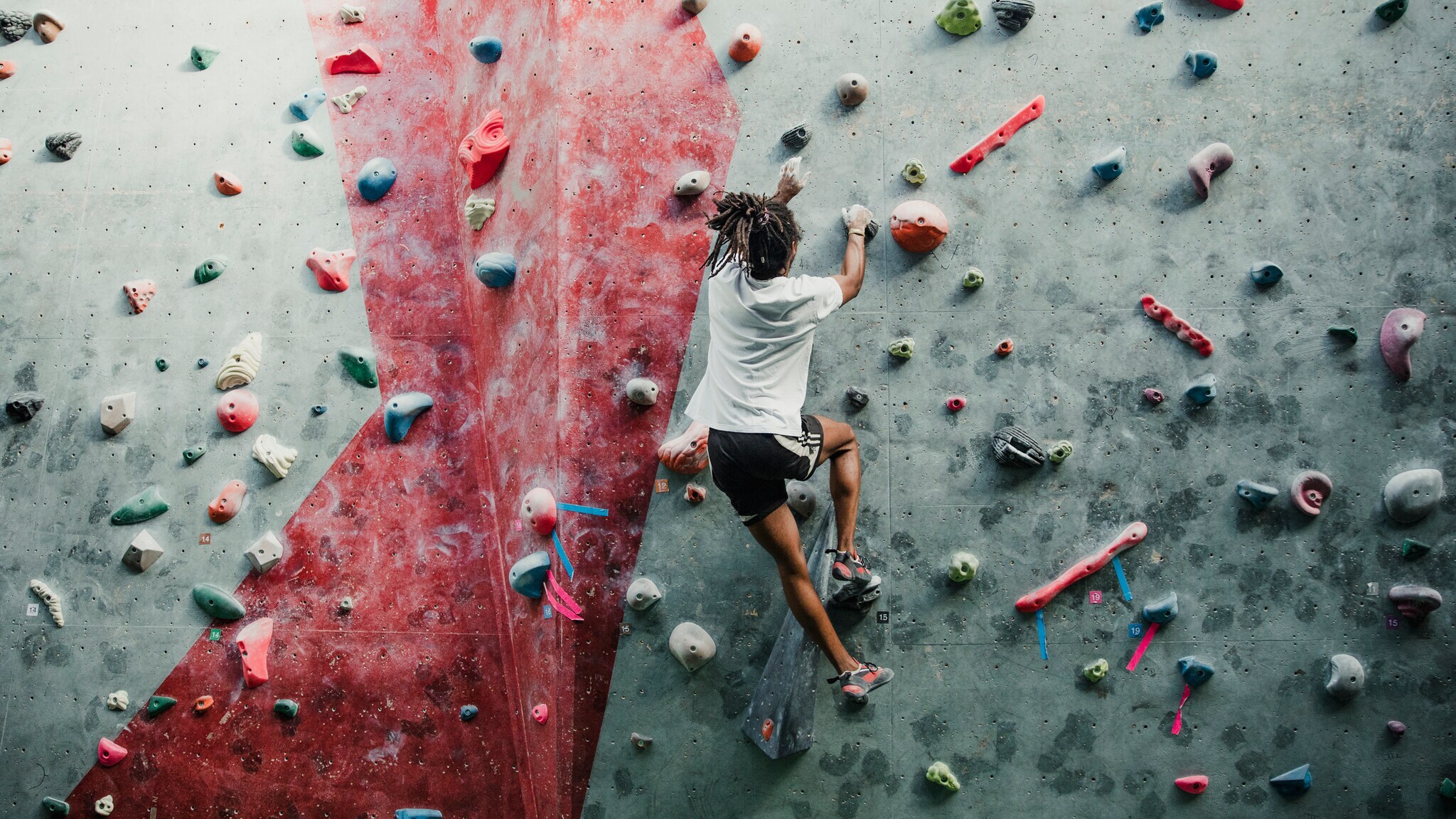 Eine Person bouldert in einem Kletterzentrum Eine Person bouldert in einem Kletterzentrum