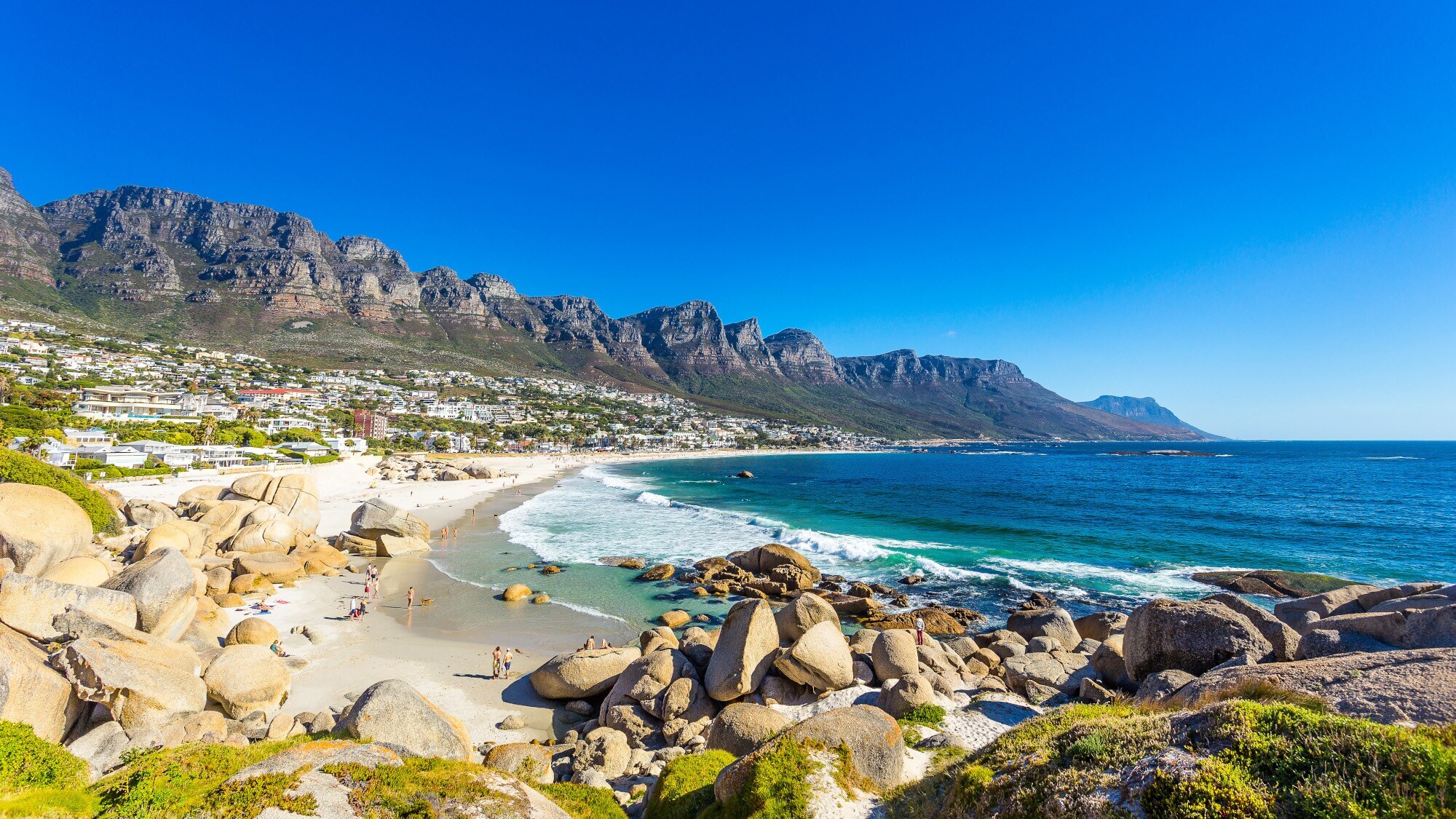 Felsige Strandbucht bei Kapstadt mit Gebirgskette im Hintergrund Felsige Strandbucht bei Kapstadt mit Gebirgskette im Hintergrund