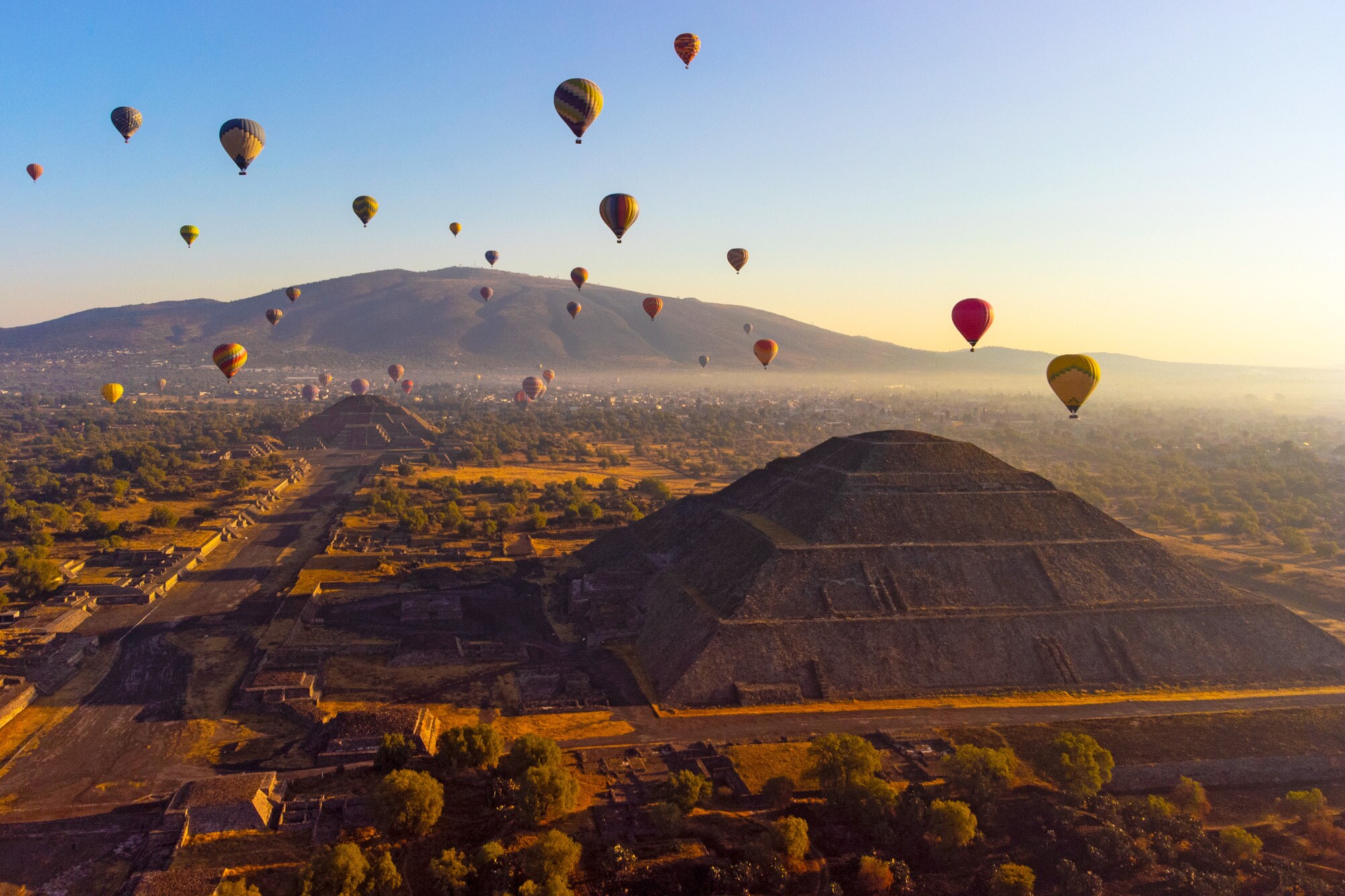 Heißluftballons über Pyramiden auf einer archäologischen Ruinenstätte bei Sonnenaufgang Heißluftballons über Pyramiden auf einer archäologischen Ruinenstätte bei Sonnenaufgang