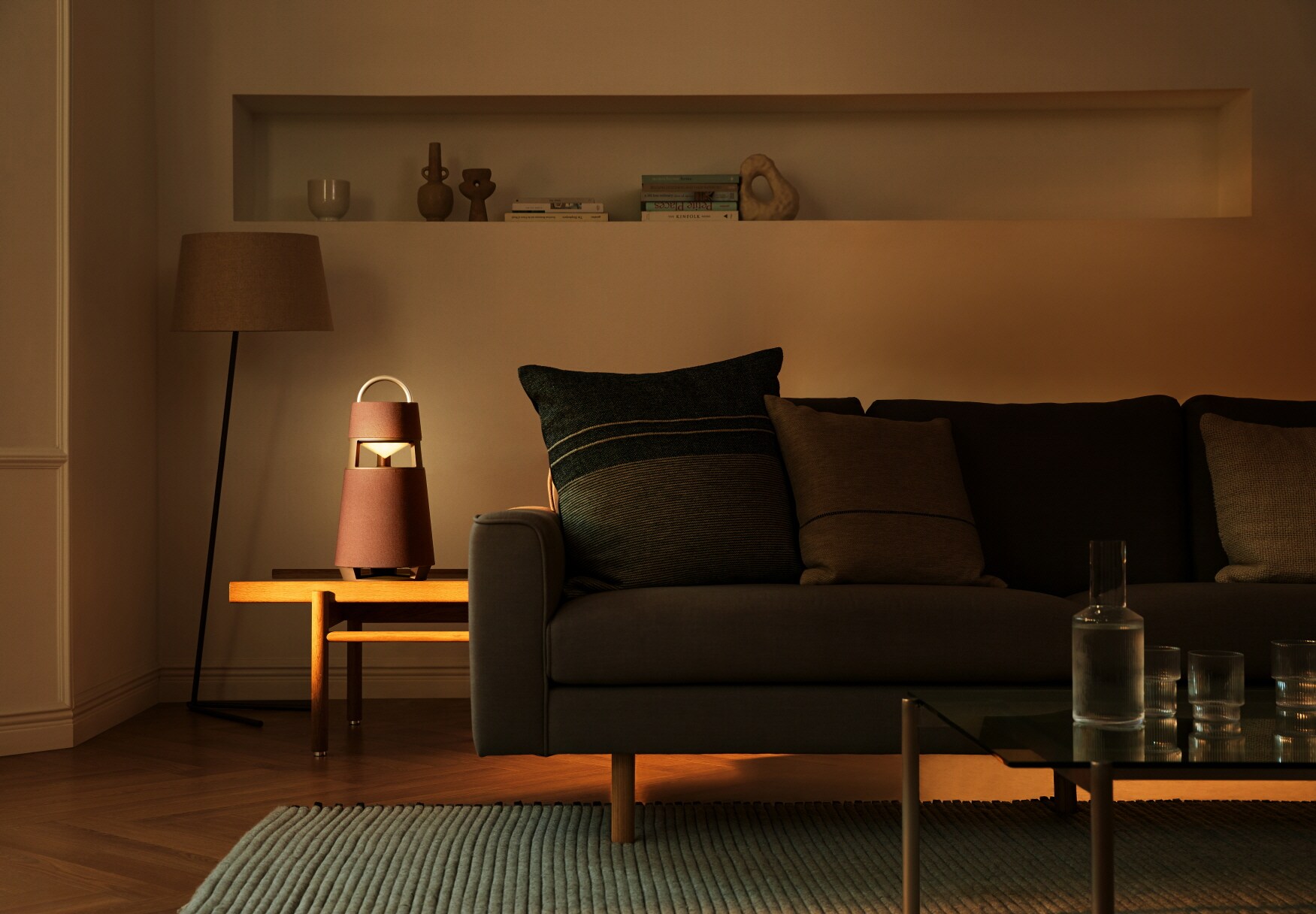 Ein kegelförmiger Bluetooth-Lautsprecher im modernen Design auf einem Tisch neben einer Couch Ein kegelförmiger Bluetooth-Lautsprecher im modernen Design auf einem Tisch neben einer Couch