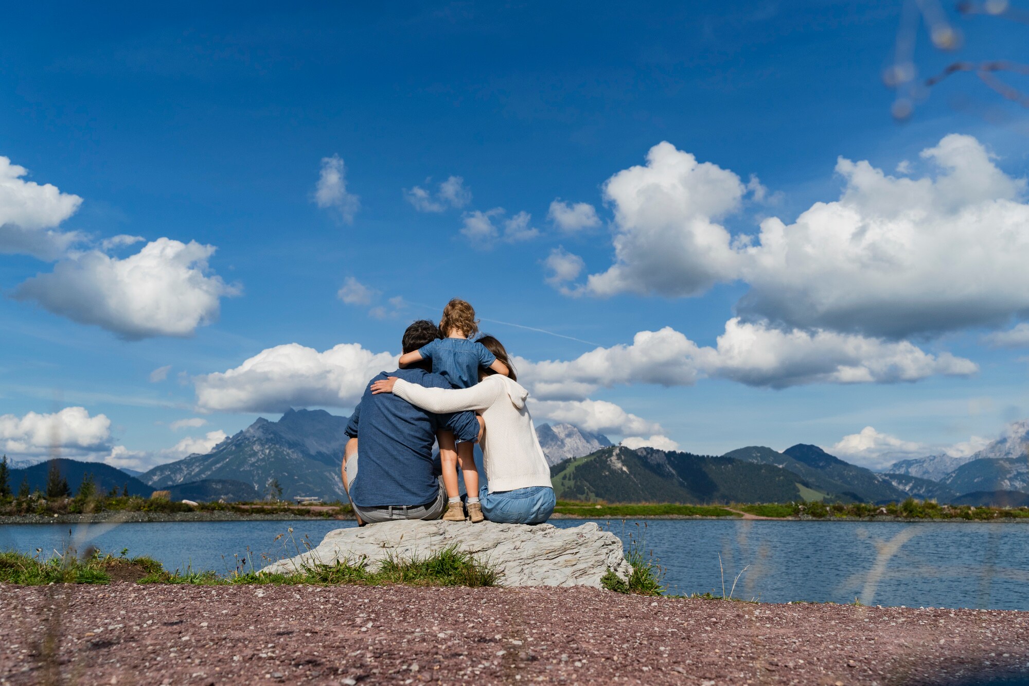 Eine Familie am Ufer eines Sees mit Bergpanorama