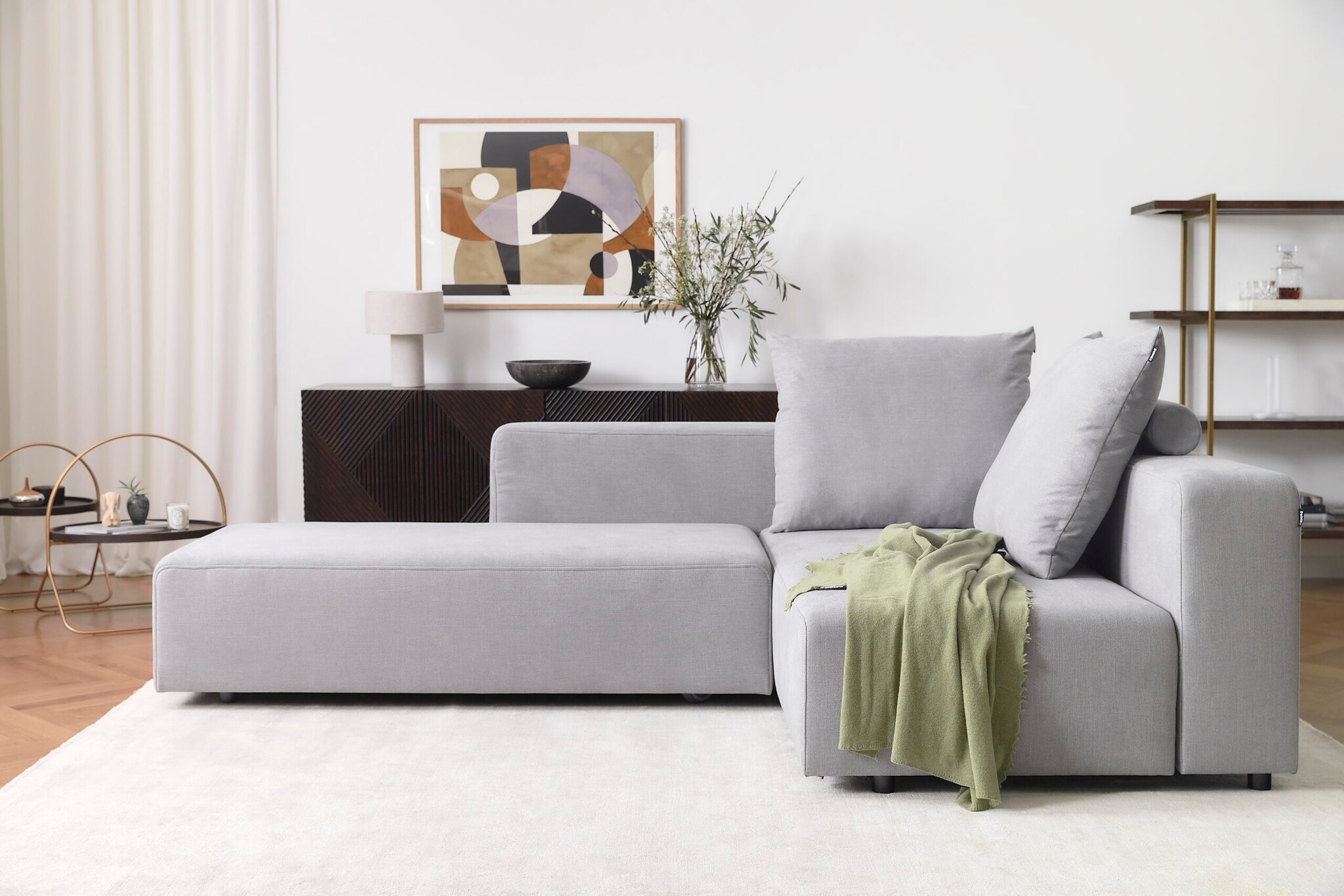 Ein graues Stoffsofa im kubistischen Design in einem modernen Wohnzimmer Ein graues Stoffsofa im kubistischen Design in einem modernen Wohnzimmer
