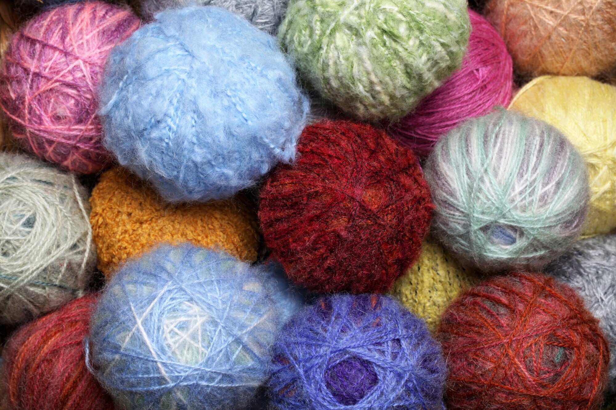 Nahaufnahme vieler Wollknäuel in unterschiedlichen Farben