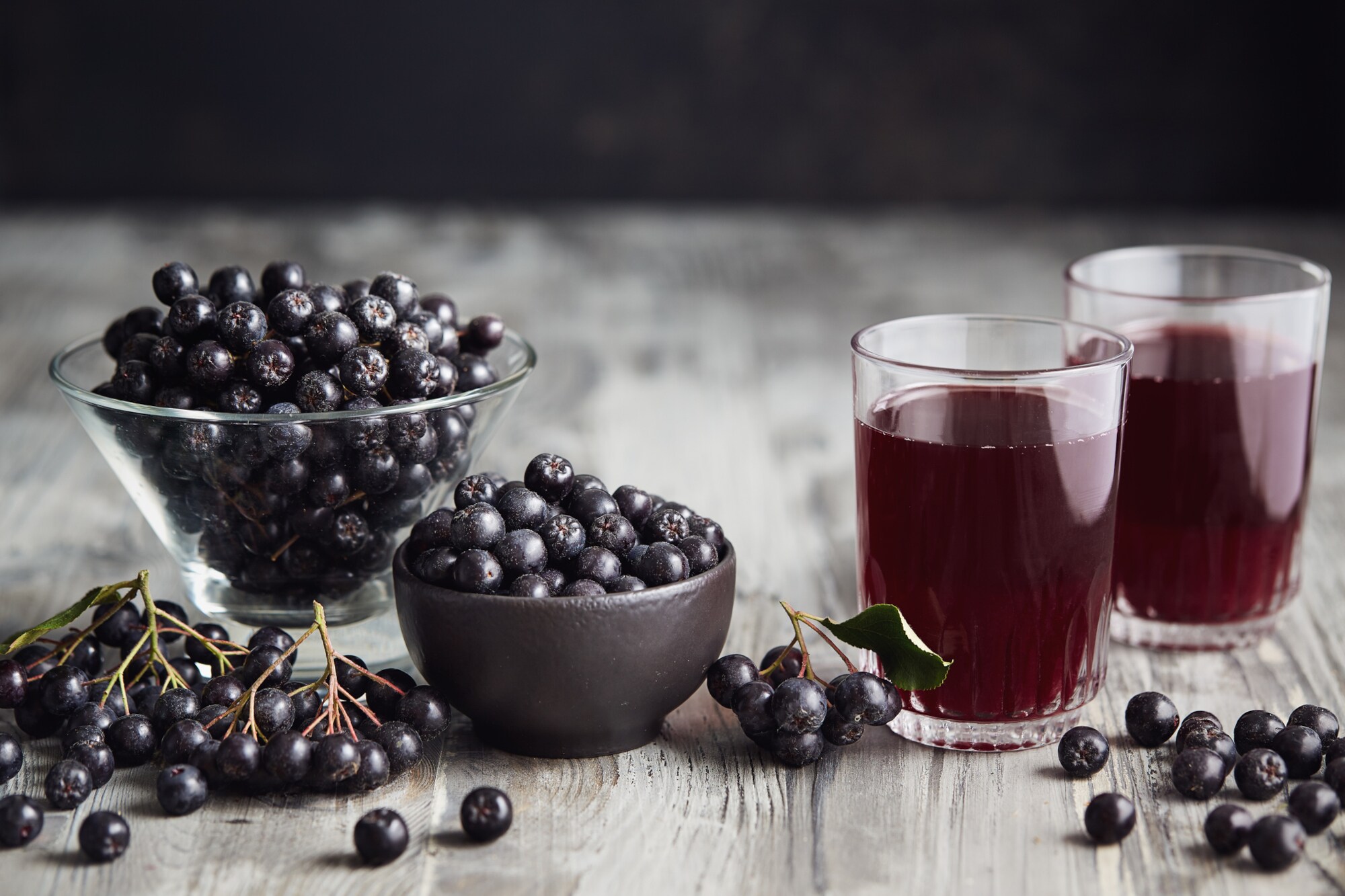 Saft aus Aroniabeeren und Aroniabeeren in Gläsern
