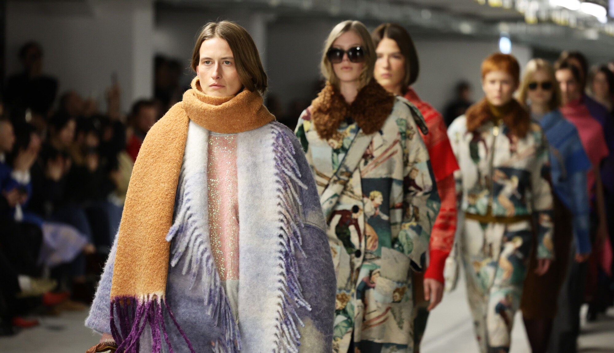 Models in farbigen weiten Mänteln beim Finale der Odeeh-Schau