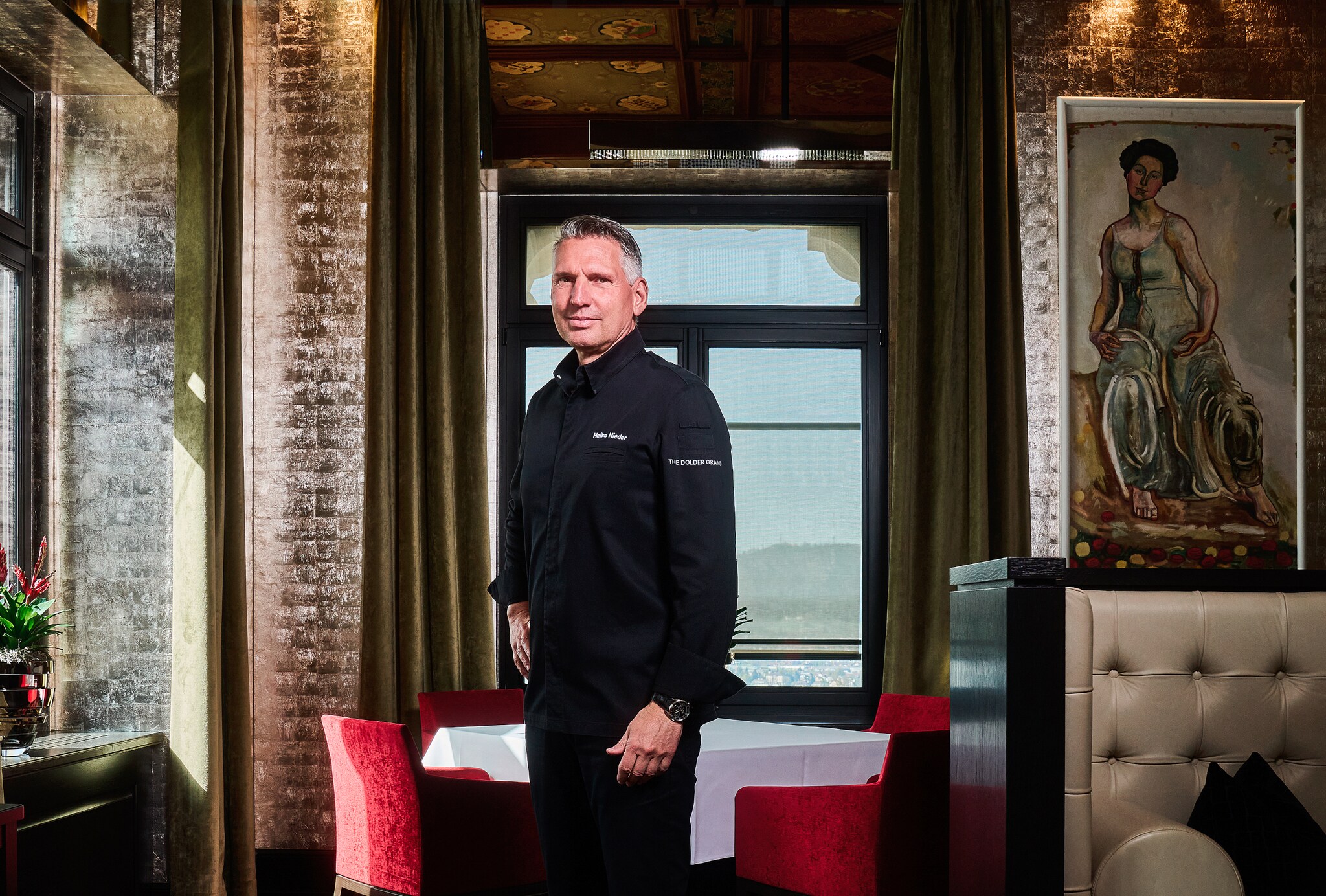 Heiko Nieder im The Restaurant vor einem weiß gedeckten Tisch mit roten Stühlen Heiko Nieder im The Restaurant vor einem weiß gedeckten Tisch mit roten Stühlen