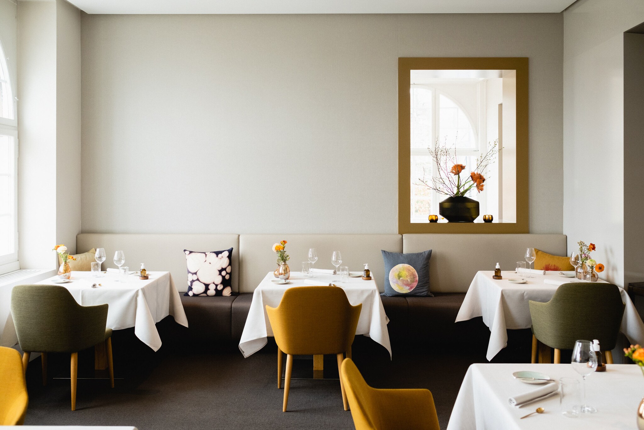 Innenraum des Stucki mit elegantem Interieur, weiß eingedeckten Tischen und Blumendeko Innenraum des Stucki mit elegantem Interieur, weiß eingedeckten Tischen und Blumendeko