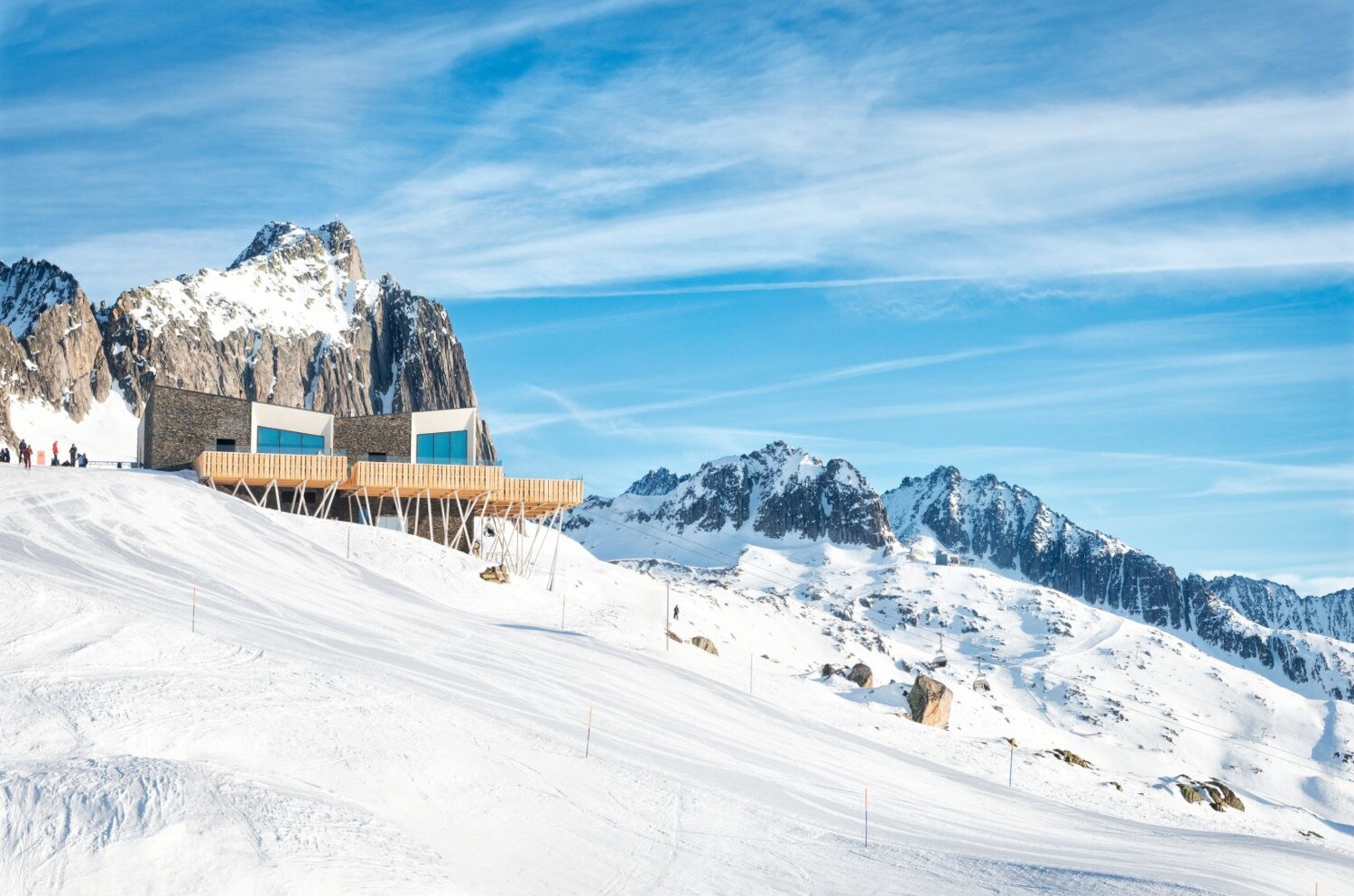 Blick auf das Restaurant The Japanese by The Chedi Andermatt, das mitten im Schnee an einem Berghang liegt Blick auf das Restaurant The Japanese by The Chedi Andermatt, das mitten im Schnee an einem Berghang liegt