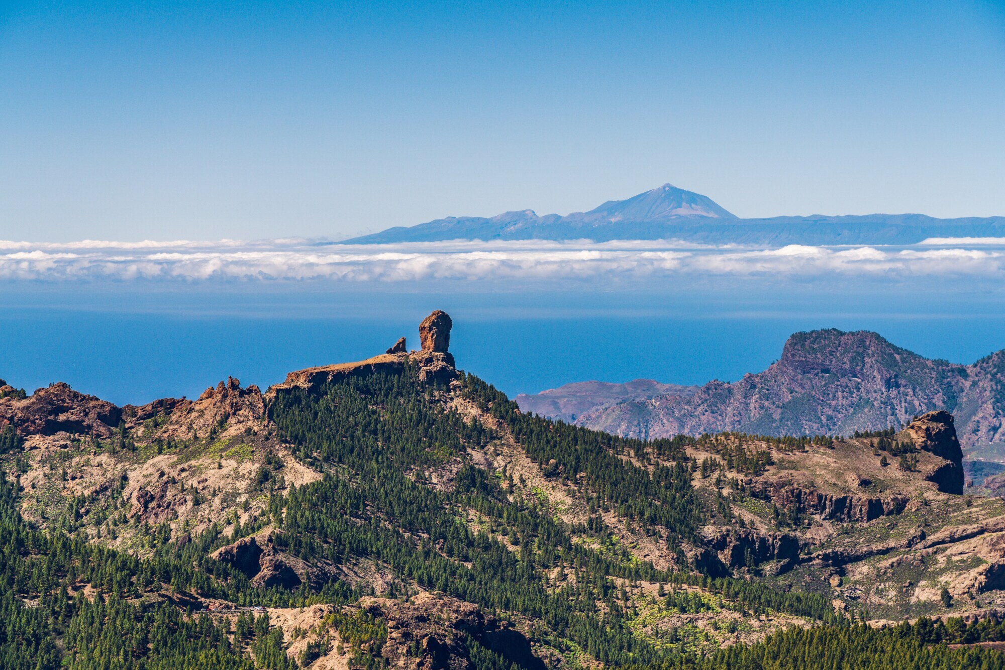 Bergpanorama in den Wolken mit einem Monolithen auf dem Gipfel