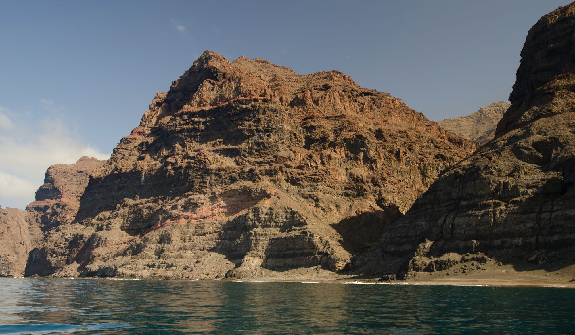 Ein kleiner, einsamer Sandstrand in einer Felsbucht