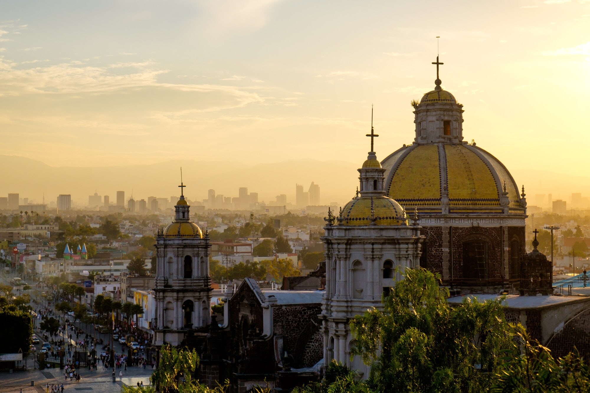 Malerische Aussicht auf die Basilika von Guadalupe mit der Skyline von Mexiko-Stadt bei Sonnenuntergang Malerische Aussicht auf die Basilika von Guadalupe mit der Skyline von Mexiko-Stadt bei Sonnenuntergang