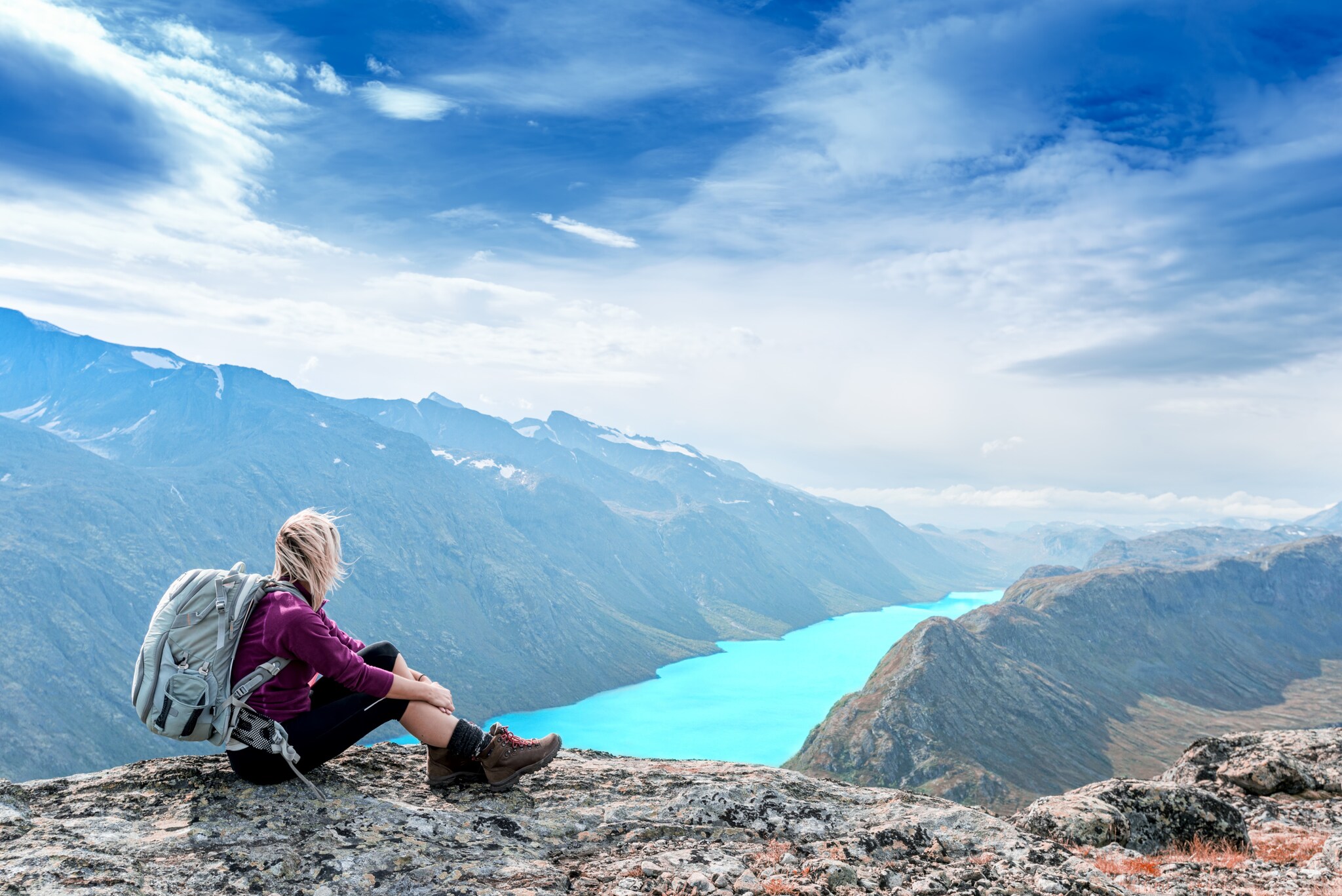 Eine Wanderin im Jotunheimen-Nationalpark mit Blick auf einen See