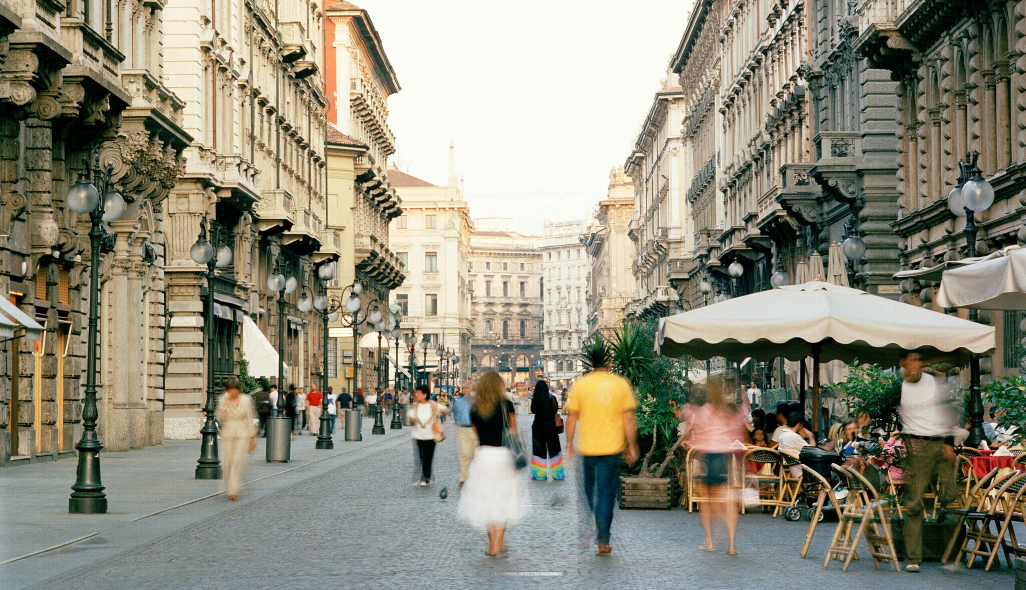 Menschen auf einer belebten Straße mit Bars und Restaurants in Mailand