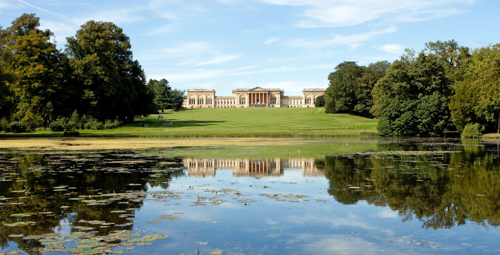 Außenansicht des Stowe House, das inmitten einer großen Grünanlage mit See liegt