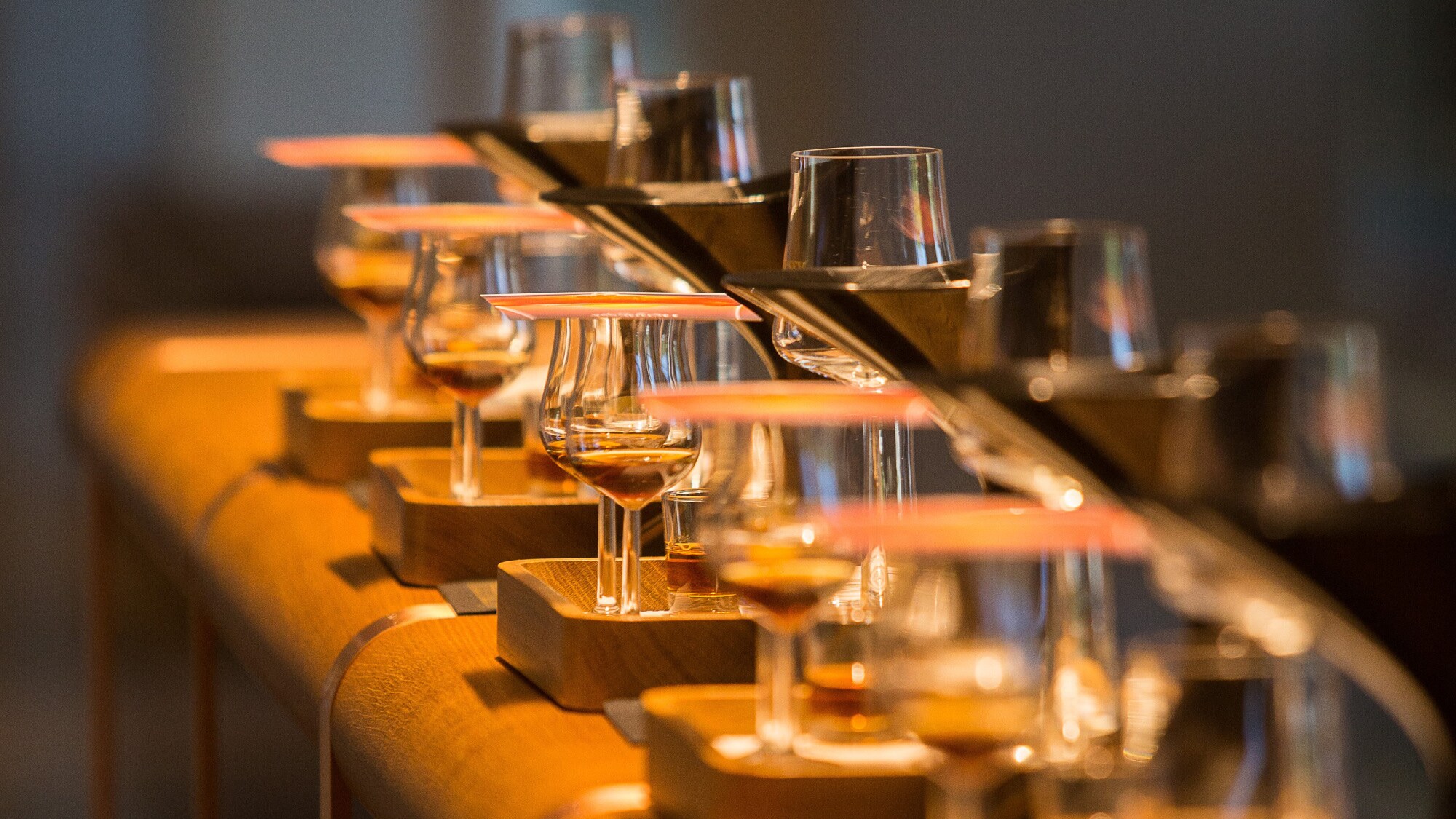 Mit Hennessy gefüllte Cognac-Gläser auf einem abgerundeten Holztresen