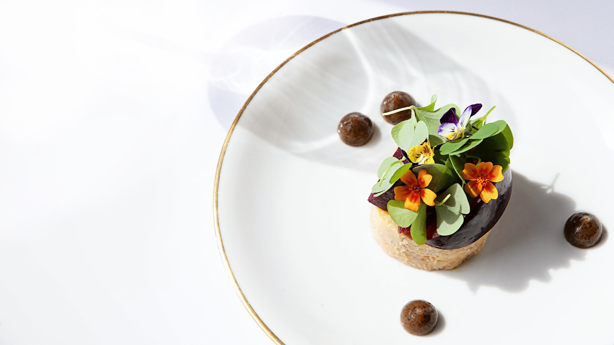 Mit Blumen dekoriertes Gericht auf einem Teller Mit Blumen dekoriertes Gericht auf einem Teller