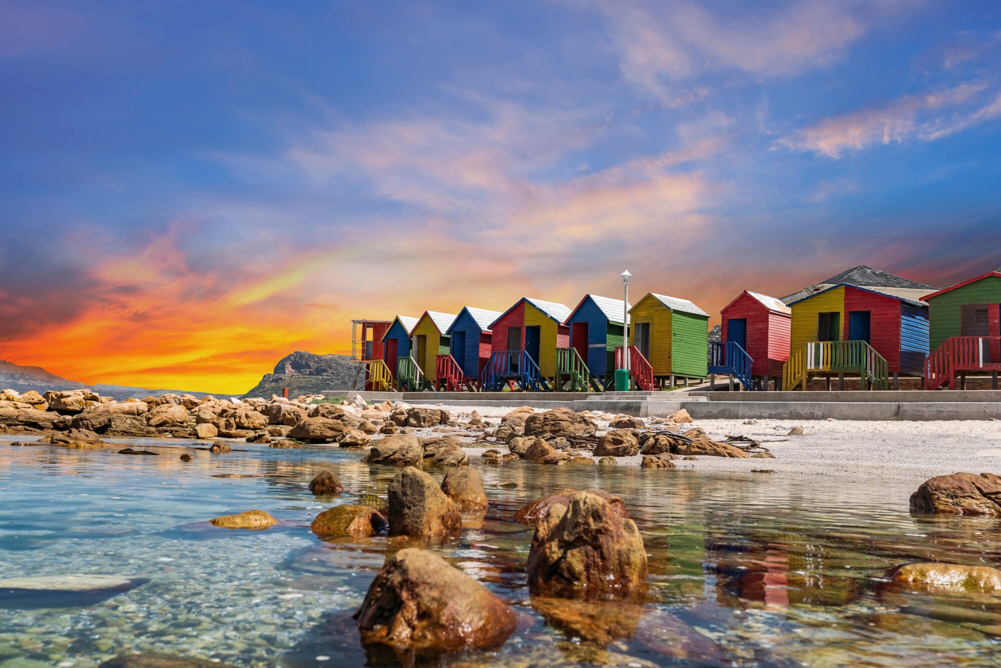 Bunte Holzhäuschen am Strand bei Sonnenuntergang