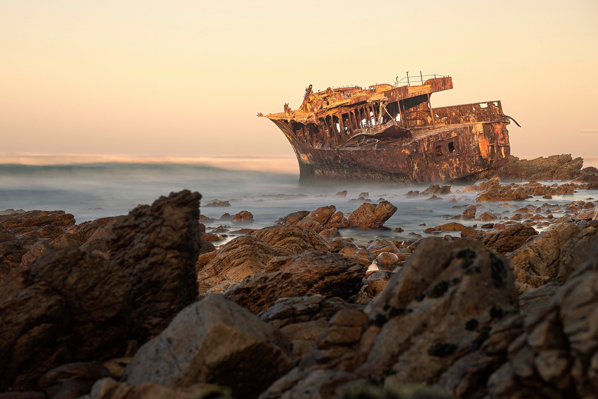 Schiffswrack an einer zerklüfteten Felsküste clear sky during sunset,Cape Agulhas,South Africa Schiffswrack an einer zerklüfteten Felsküste