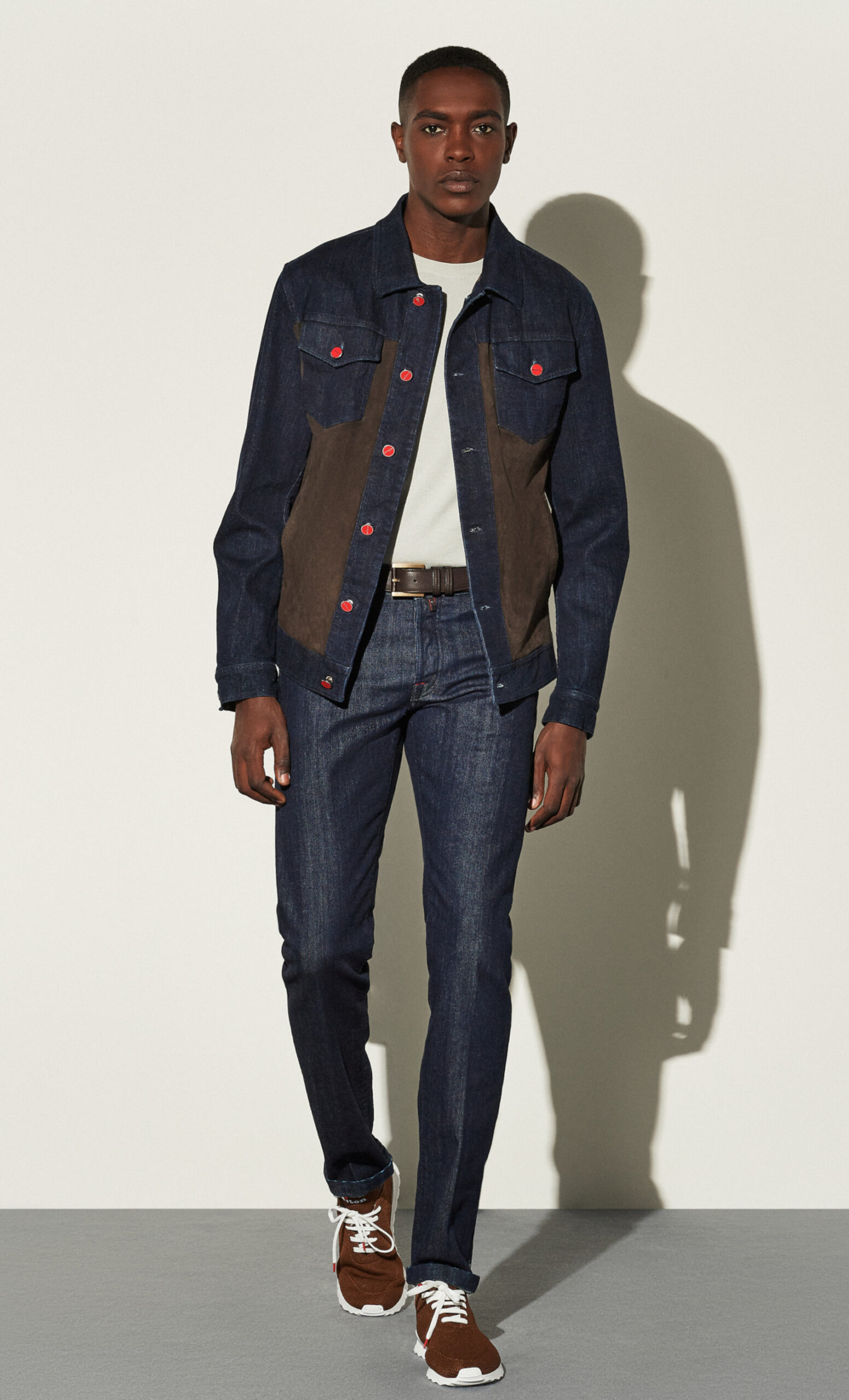 Model in Jeansjacke mit Ledereinsätzen und roten Knöpfen, Studioaufnahme