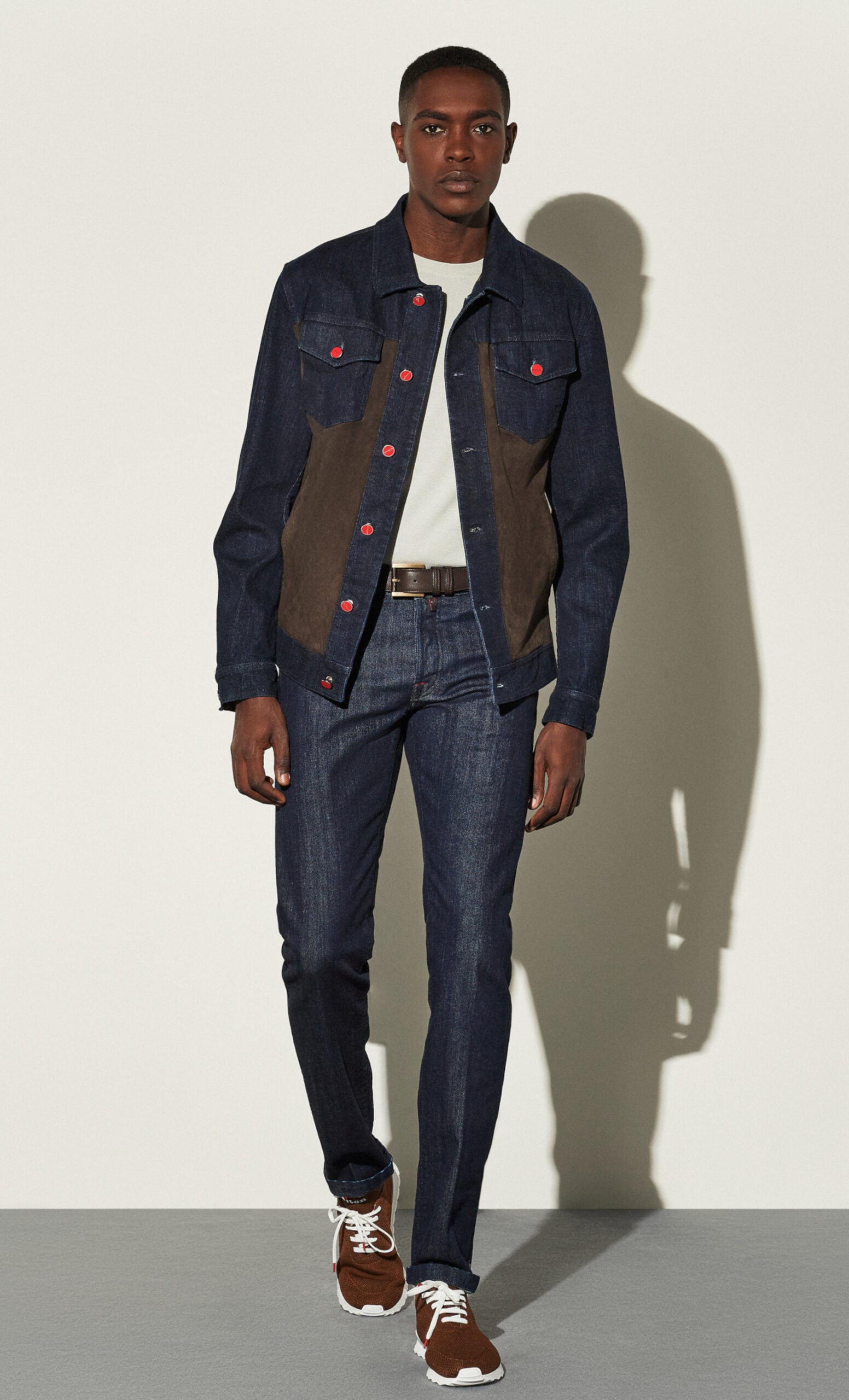 Model in Jeansjacke mit Ledereinsätzen und roten Knöpfen, Studioaufnahme Model in Jeansjacke mit Ledereinsätzen und roten Knöpfen, Studioaufnahme