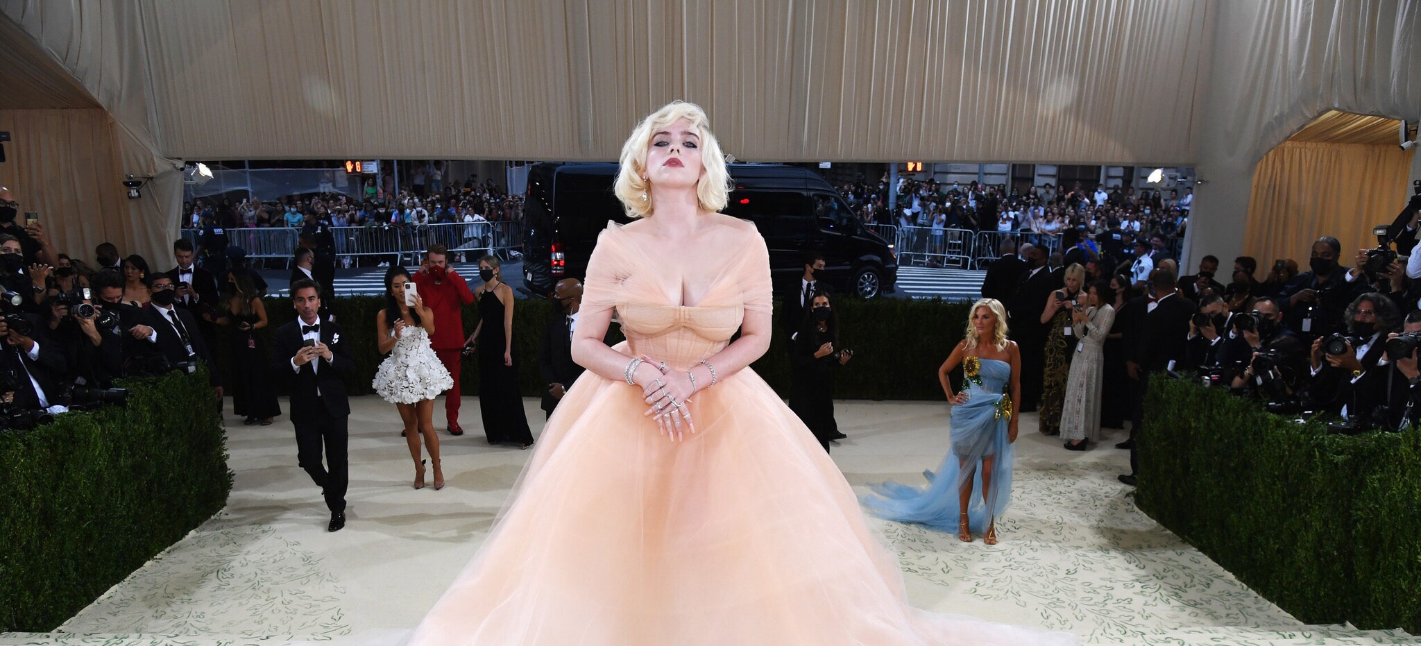 Billie Eilish posiert in hellem Abendkleid auf der Met Gala vor Fotografen