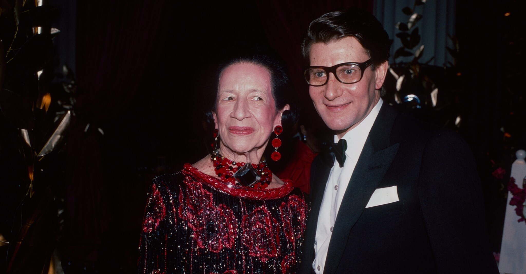 Diana Vreeland in rotem Abendkleid und Yves Saint Laurent im Anzug auf der Met Gala.