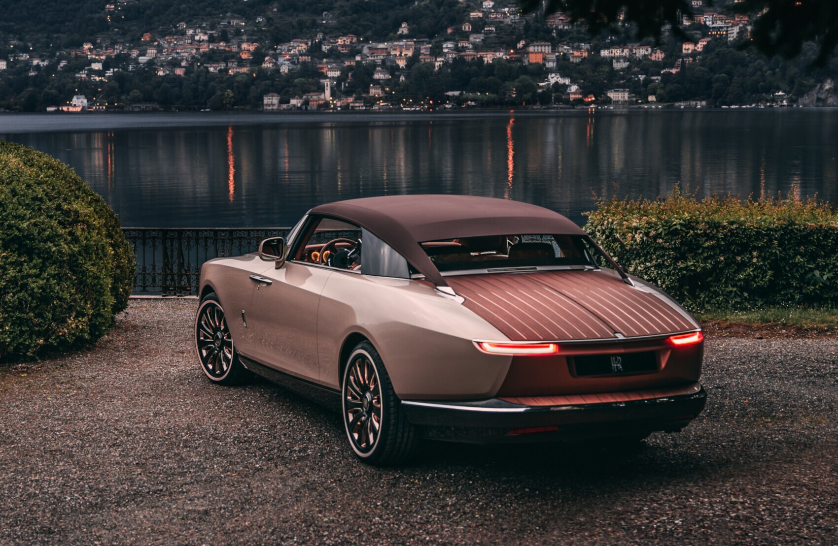 Der Rolls-Royce Boat Tail steht im Abendlicht vor einem See