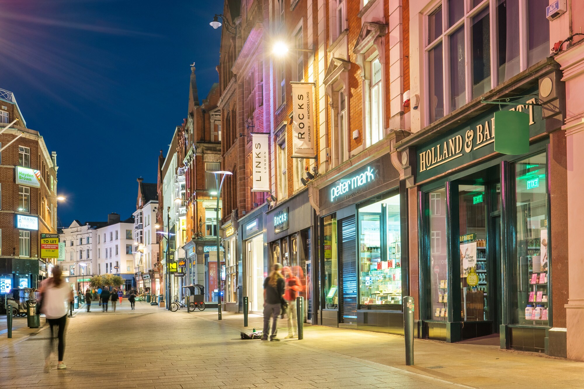 Beleuchtete Geschäfte und Pubs in der Grafton Street in der Innenstadt von Dublin