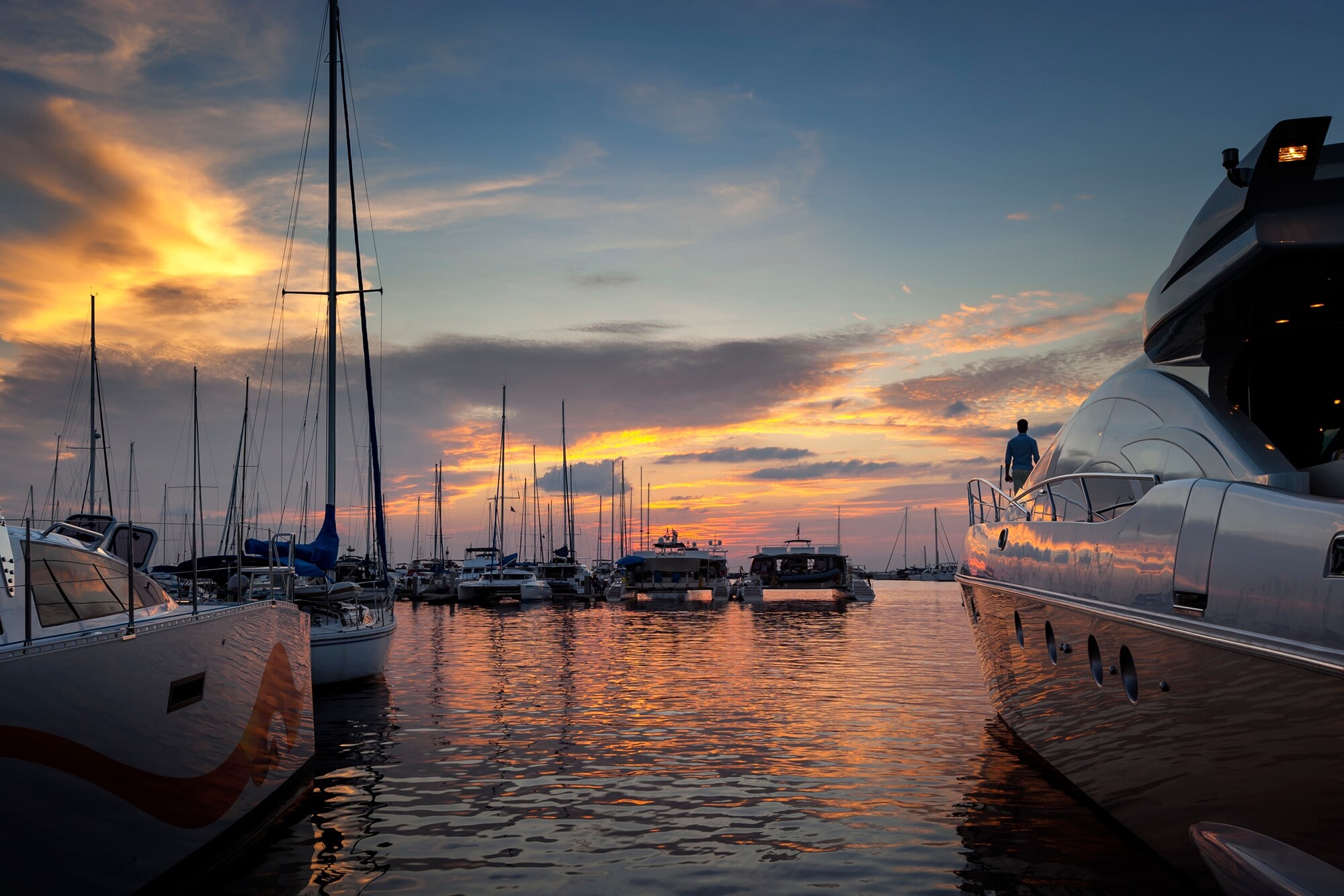 Mehrere Jachten, die bei Sonnenuntergang in einem kleinen Hafen stehen. Mehrere Jachten, die bei Sonnenuntergang in einem kleinen Hafen stehen.