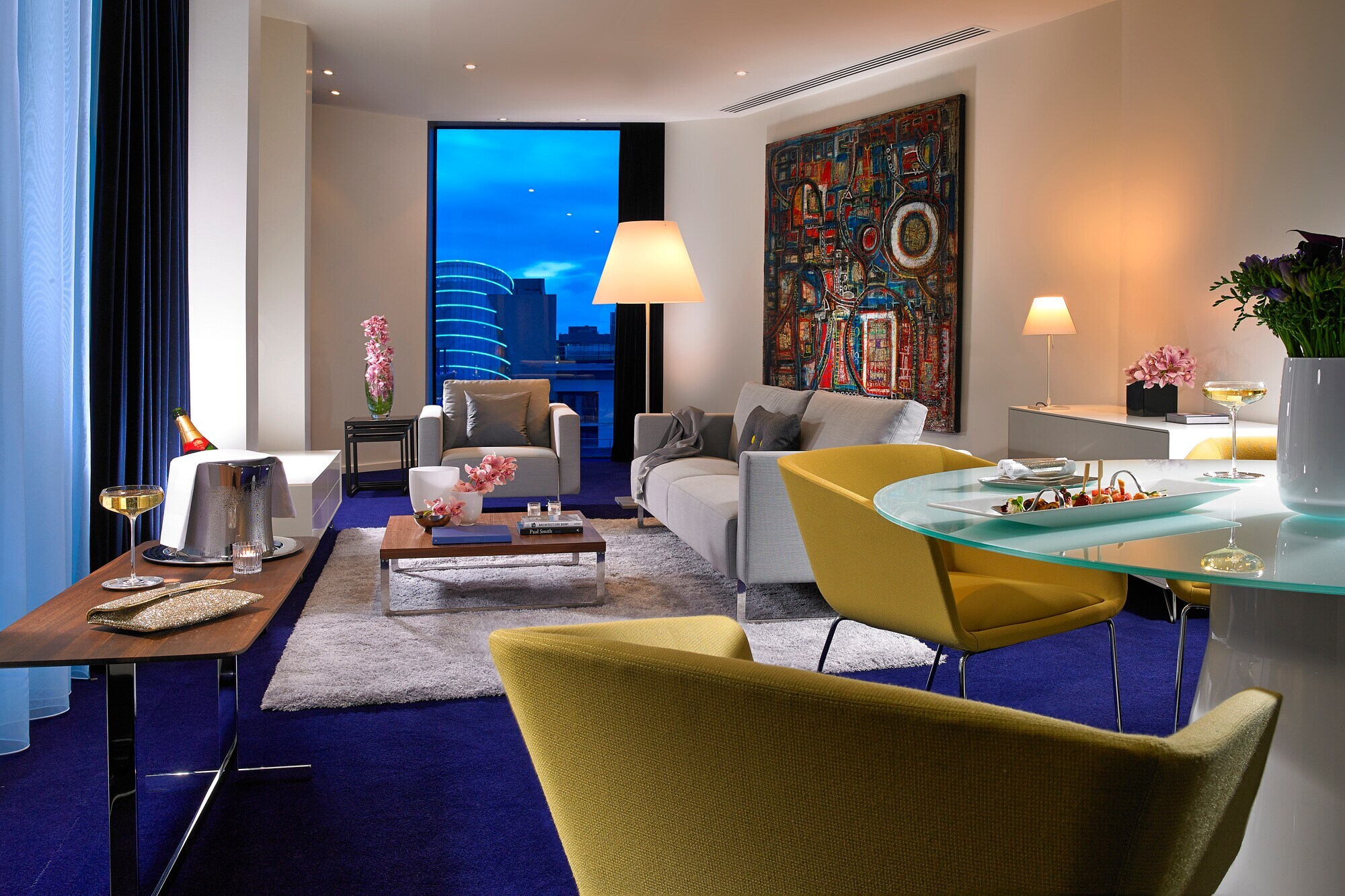 Eine moderne, farbenfroh eingerichtete Hotelsuite mit Stadtblick