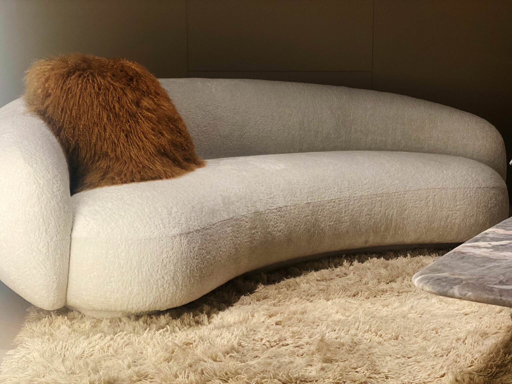 Geschwungenes cremeweißes Sofa von Tacchini mit beigefarbenem Fellkissen und Flokatiteppich. Geschwungenes cremeweißes Sofa von Tacchini mit beigefarbenem Fellkissen und Flokatiteppich.