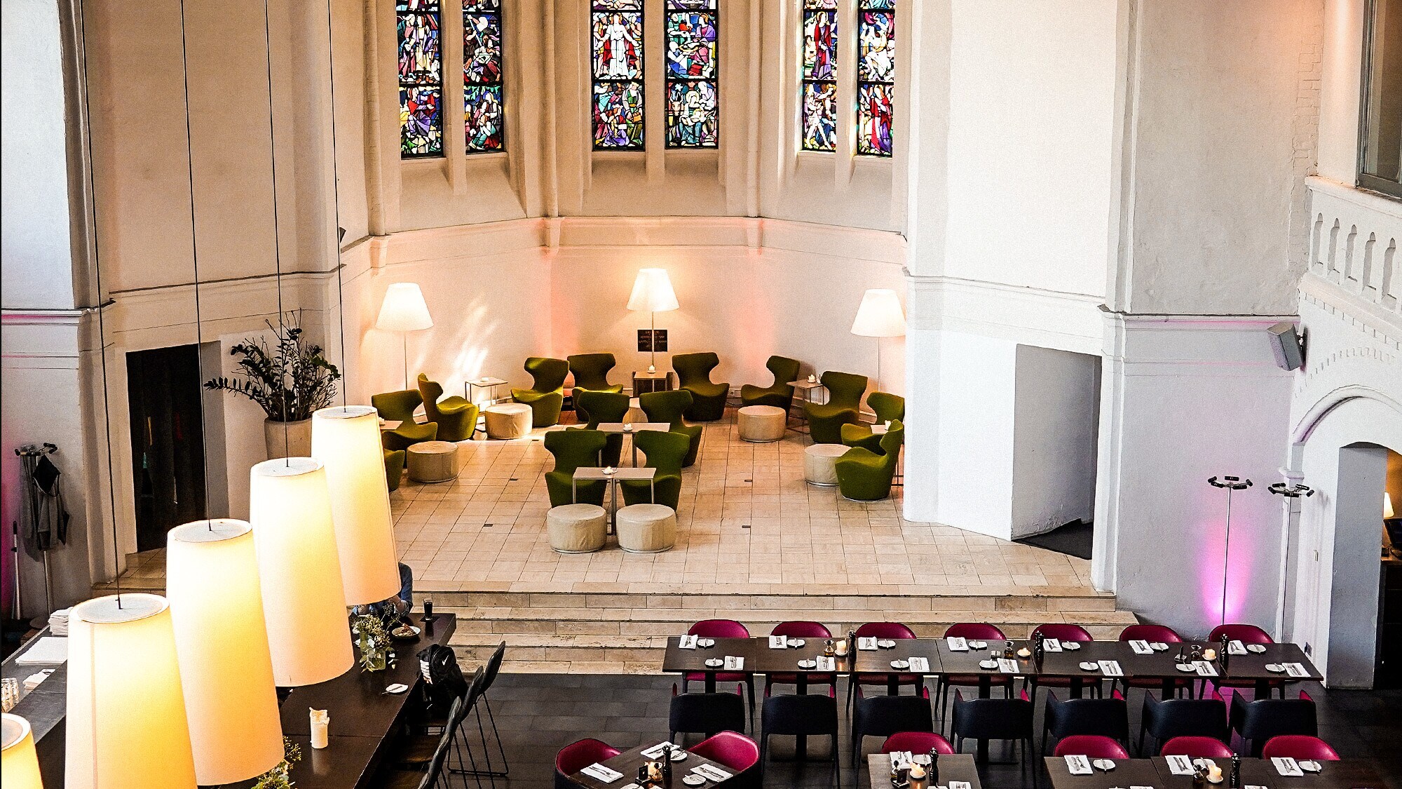 Blick auf Restauranttische und Stühle im Inneren einer Kirche Blick auf Restauranttische und Stühle im Inneren einer Kirche