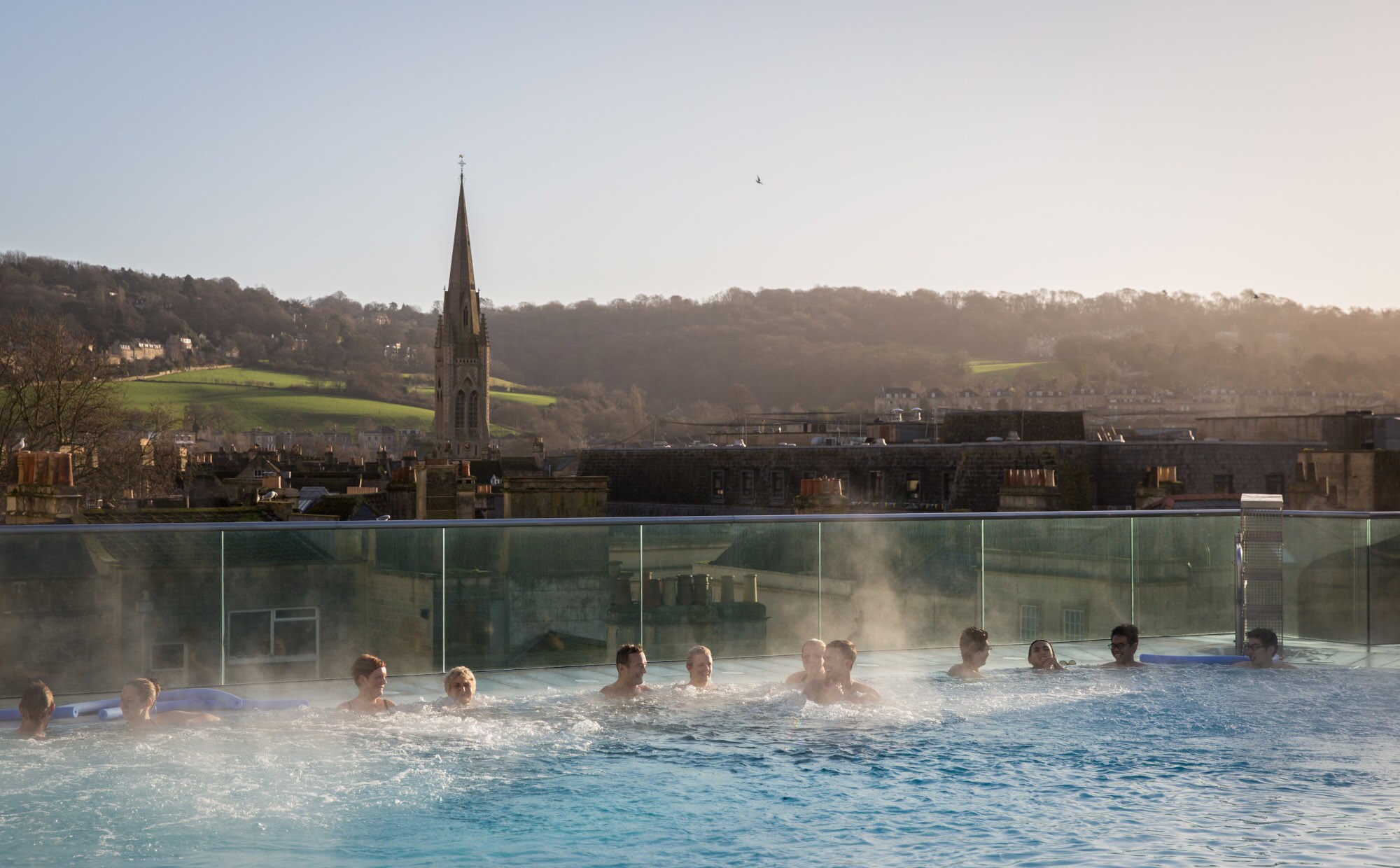 Badende in einem Rooftop-Pool mit Blick auf das historische Bath