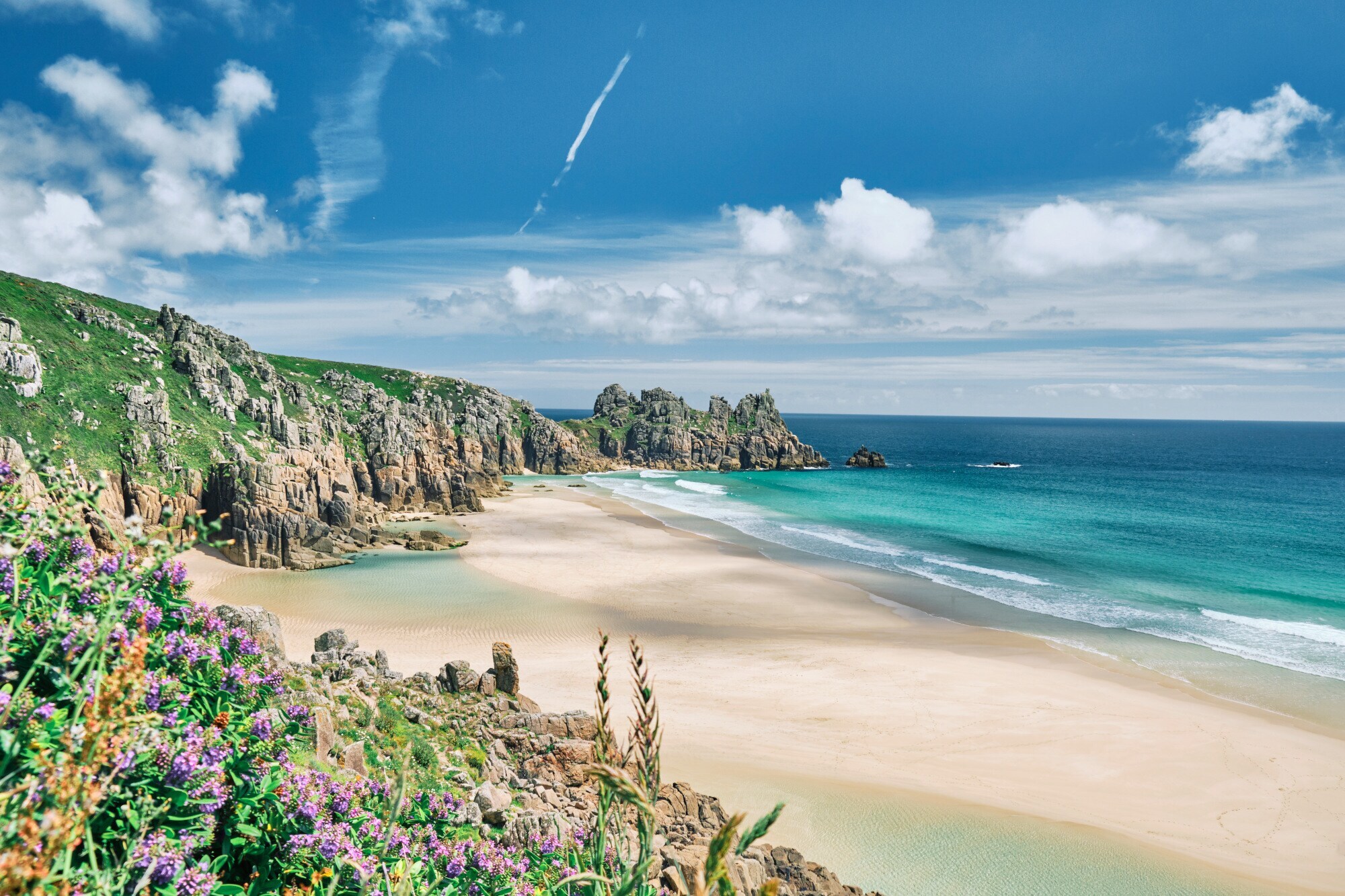 Blick auf die Küste von Cornwall mit Sandstrand, kristallblauem Wasser und Felsvorsprüngen