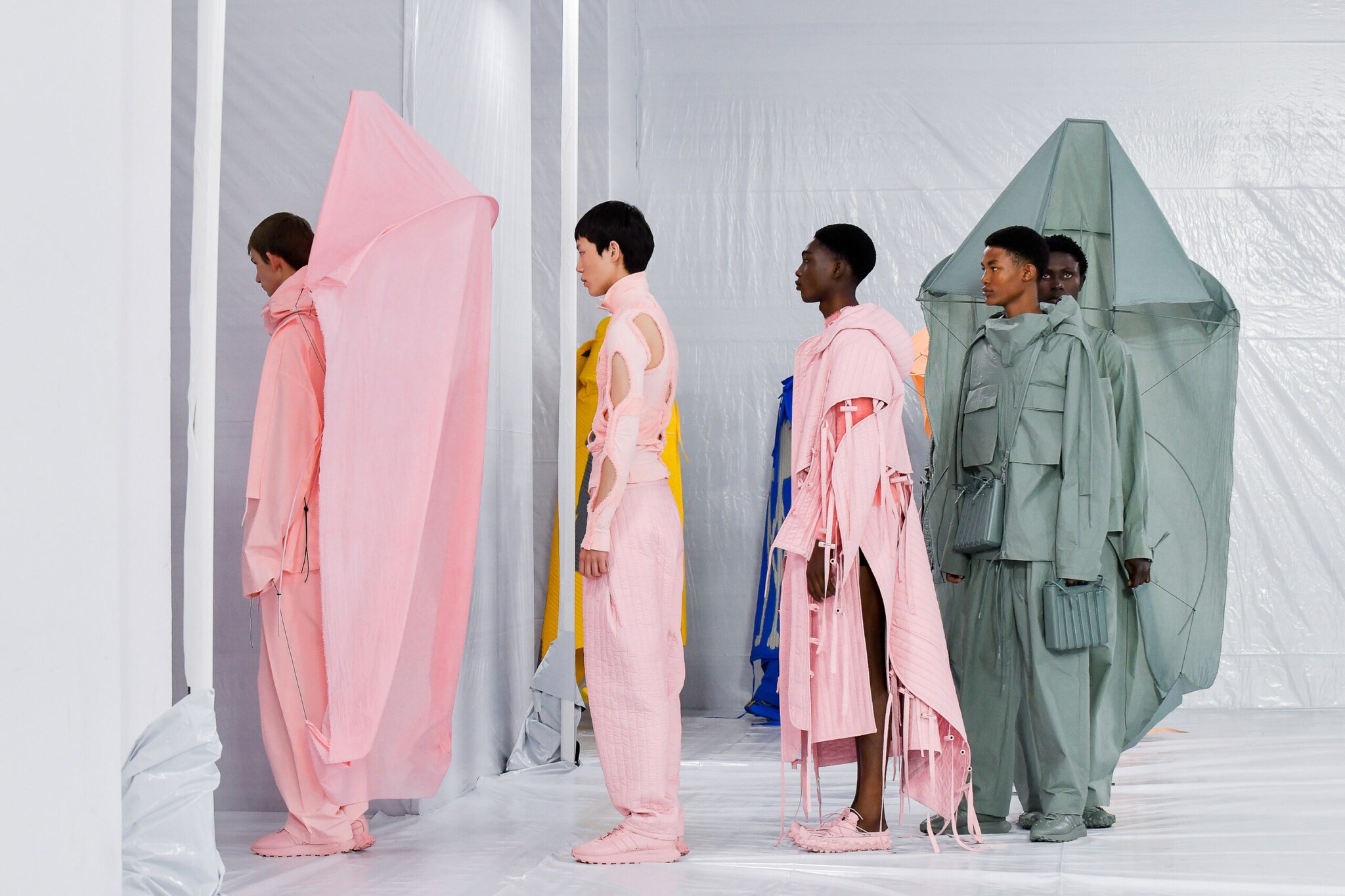 Mehrere Models stehen hintereinander auf einem Catwalk.