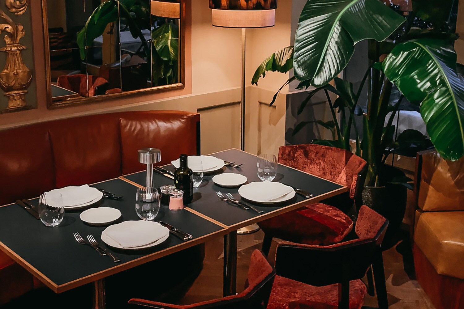 Ein gedeckter Tisch in einem dunkel und edel eingerichteten Raum.