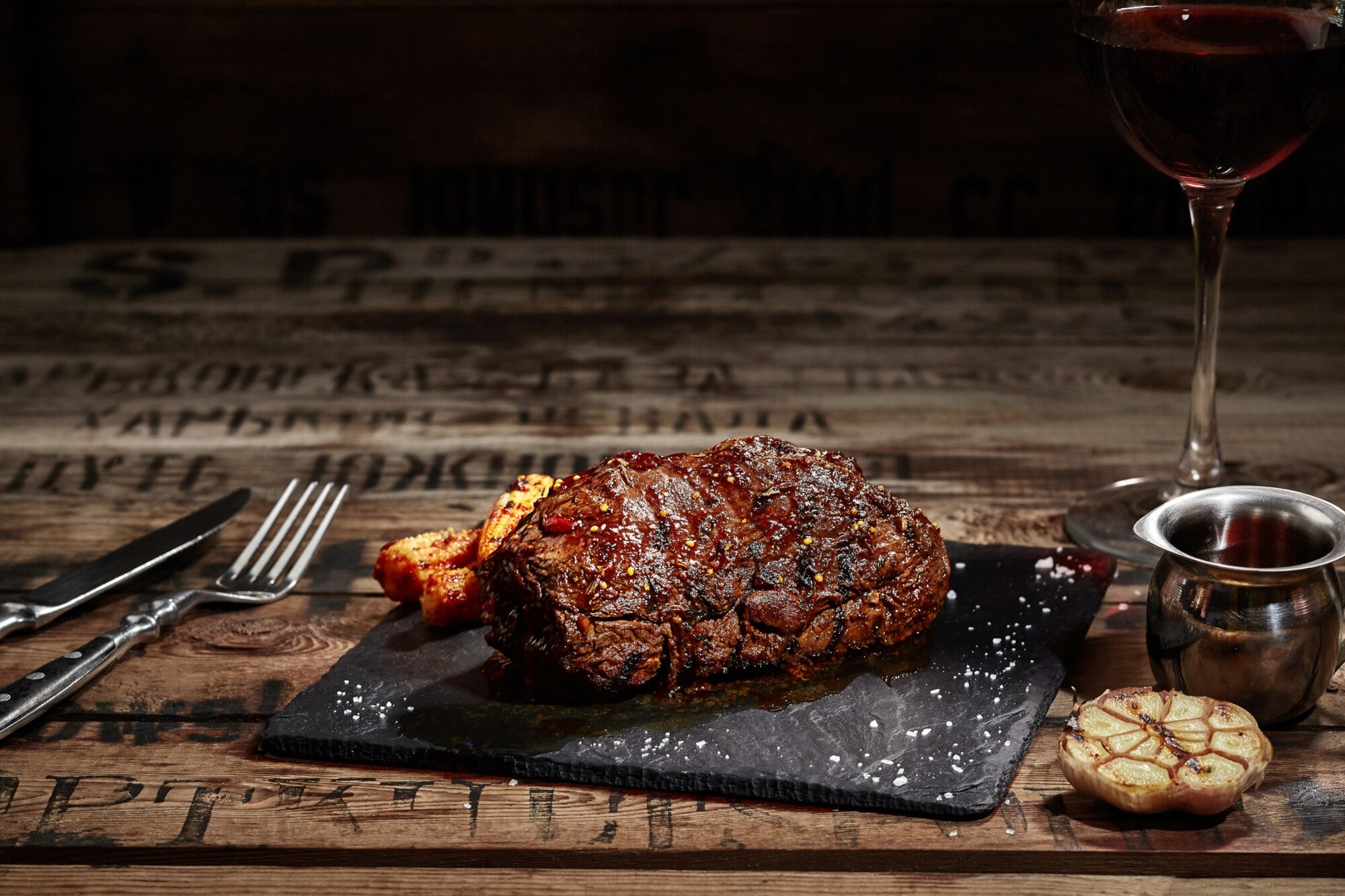 Ein gebratenes Steak liegt auf einer Granitplatte auf einem Holztisch Ein gebratenes Steak liegt auf einer Granitplatte auf einem Holztisch