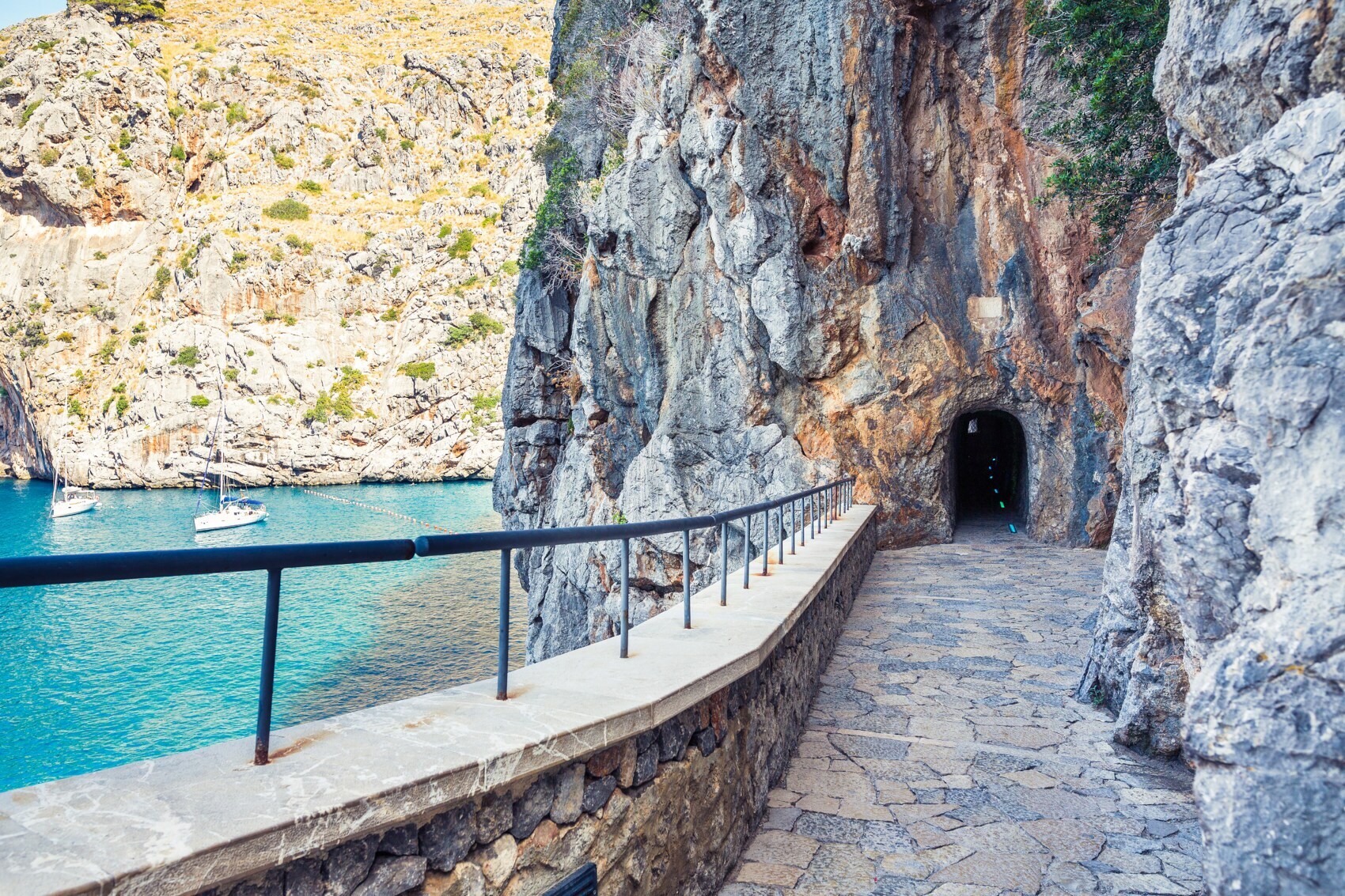 Promenade, die durch einen in den Fels geschlagenen Tunnel führt