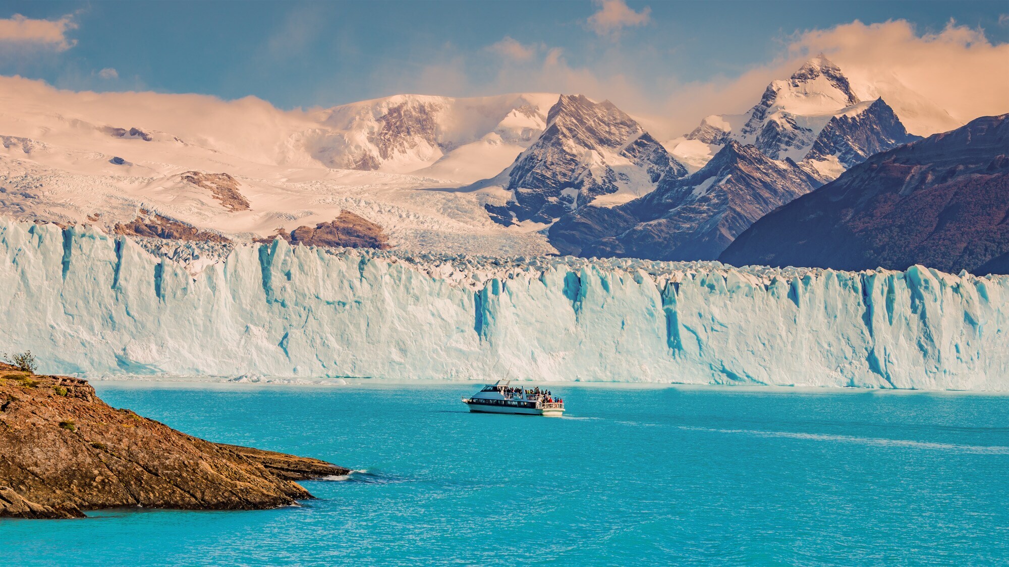Panoramaaufnahme des Gletschers Perito Moreno mit einem Touristenboot, das durch türkisblaues Wasser fährt